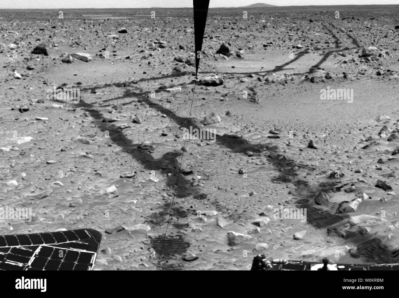 Questa coppia di perforato-insieme di immagini da spirito posteriore della telecamera di navigazione rivela una lunga e percorso roccioso di quasi 240 metri (787 piedi) rover guidato dal suo sito di atterraggio a Gusev Crater. Il lander può ancora essere visto in lontananza, ma non potrà mai essere 'home' di nuovo per il cammino rover. Questa immagine è anche un omaggio alla efficacia del autonomo sistema di navigazione che i rover utilizzano durante parti delle loro unità marziano. Invece di guidare direttamente attraverso il 'Cava' visto nella metà destra dell'immagine, la navigazione autonoma sistema spirito guidato intorno alla alta cresta borde Foto Stock