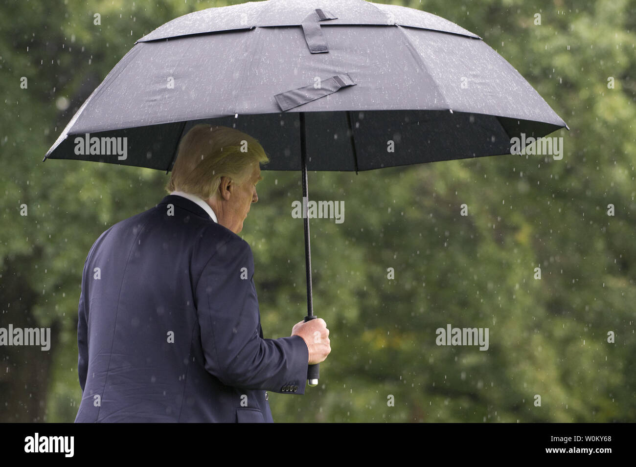 Stati Uniti Presidente Donald Trump passeggiate sotto la pioggia a Marina Uno come lui cammina attraverso il South Lawn come egli si diparte la Casa Bianca a Washington il 6 settembre 2017. Il presidente sarà in visita in North Dakota oggi. Foto di Pat Benic/UPI Foto Stock