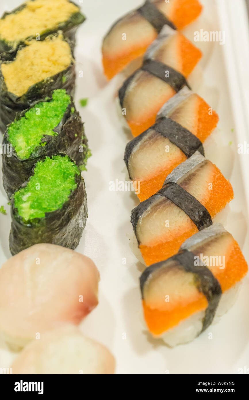 Un piatto di sushi giapponese di close-up con strisce di cetriolo di uova, pesce e laver Foto Stock
