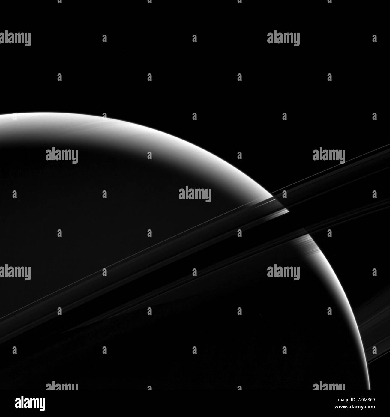 Sebbene solo una scheggia di Saturno faccia soleggiato è visibile in questa vista, il possente gigante di gas pianeta ancora domina la vista. Questa guarda verso il lato non illuminato degli anelli da circa 7 gradi al di sotto del piano dell'anello. L'immagine è stata scattata nella luce verde con la sonda Cassini ampio angolo fotocamera su gennaio 18, 2017. Da questo punto di vista appena al di sotto del piano dell'anello, la densa anello B diventa scuro e sostanzialmente opaco, lasciando quasi nessuna luce passa attraverso. Ma un po' di luce riflessa dal pianeta passa attraverso il meno denso di un anello che viene visualizzata sopra l'anello B in questa foto. Th Foto Stock