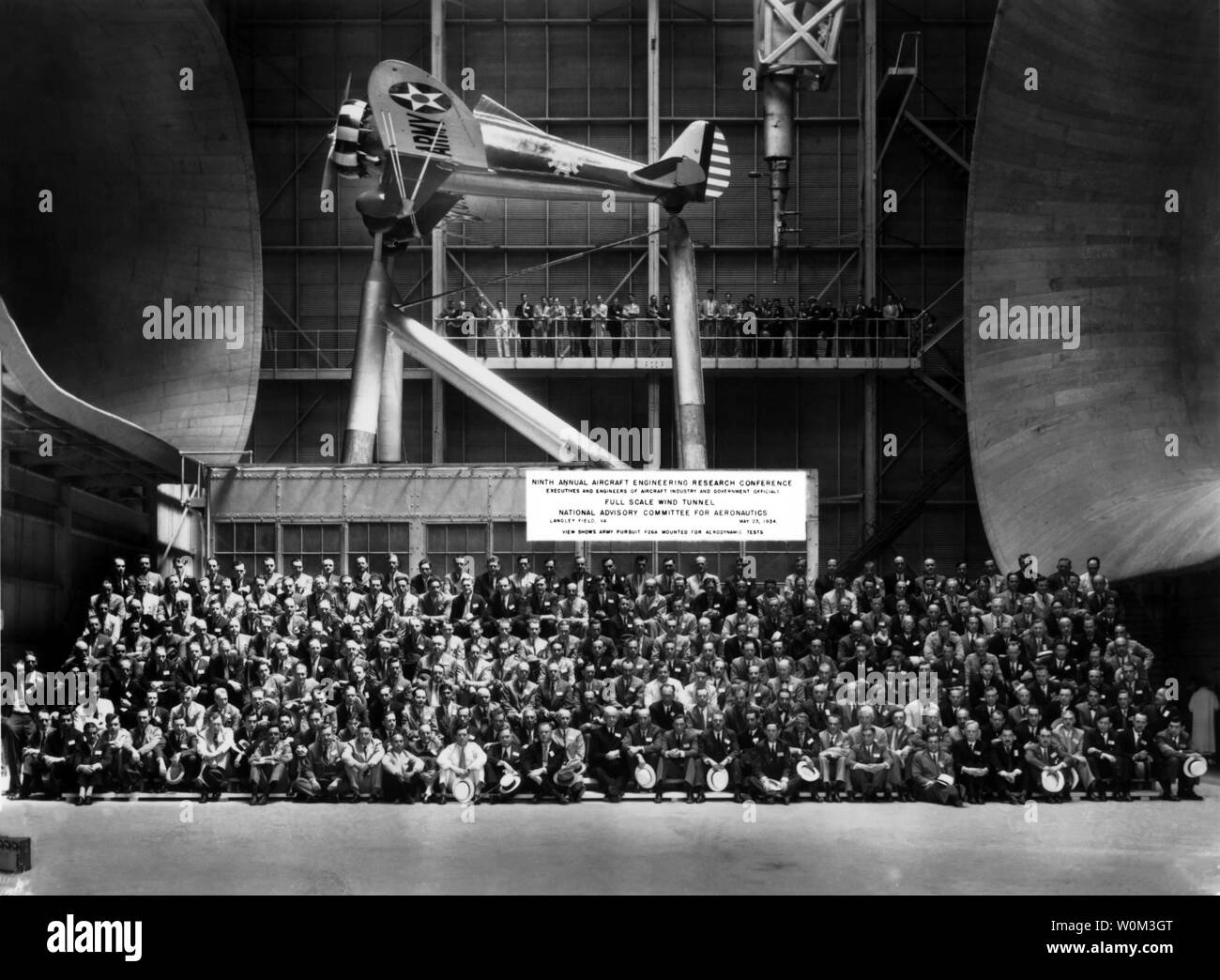 Questa foto è stata scattata a Langley del centro di ricerca di Tunnel Full-Scale durante il 1934 Aircraft Engineering Research Conference, con Orville Wright, Charles Lindbergh e Howard Hughes in frequenza. Il Tunnel Full-Scale impianto è stato costruito nel 1930 per testare full-sized aeromobili e grandi modelli. Le gallerie del vento sono accuratamente progettate strutture artificiali che canale e spostare aria o altri gas in modo tale che la corrente aereiforme effetti sugli oggetti sono determinati senza effettivo decollo e volo. La NASA/UPI Foto Stock