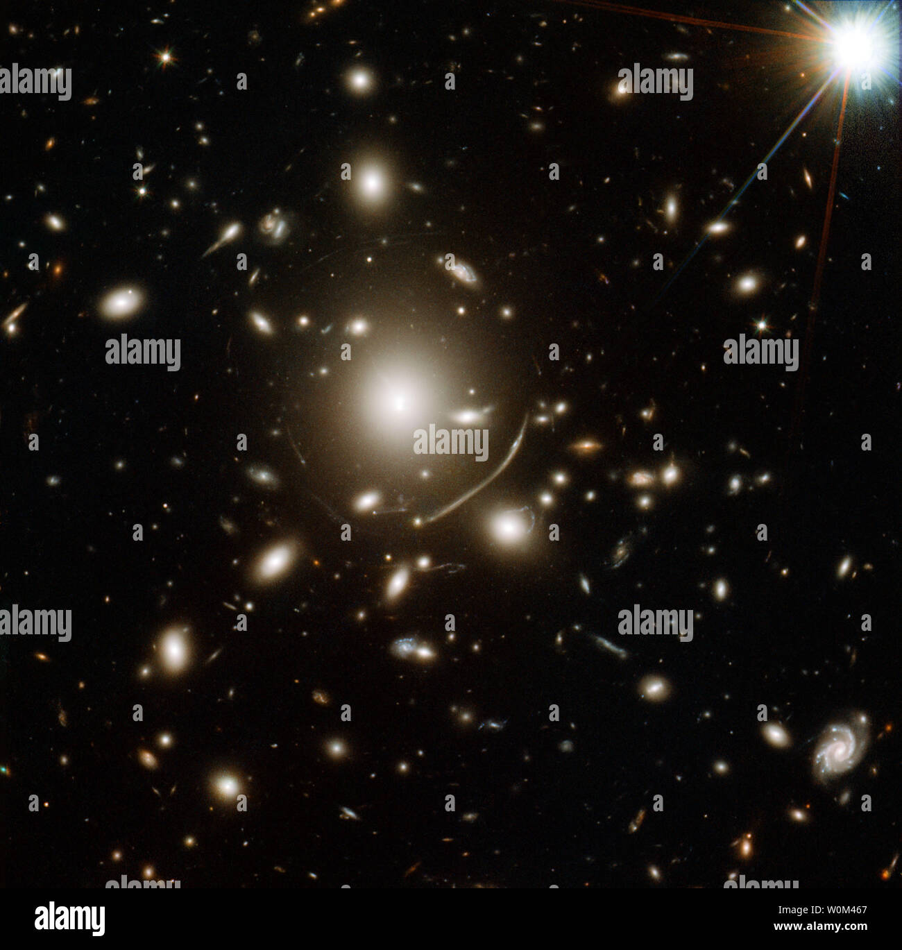 Il gigante cluster Galaxy nel centro di questa immagine, rilasciato il 12 aprile 2011, contiene così tanto la materia oscura massa che la sua gravità si piega alla luce di più oggetti distanti. Questo significa che per molto distanti galassie in background, il cluster del campo gravitazionale agisce come una sorta di lente di ingrandimento, piegatura e concentrando l'oggetto distante la luce verso Hubble. Utilizzando la NASA/ESA telescopio spaziale Hubble, gli astronomi hanno scoperto che le galassie più brillanti nel cluster Galaxy 'ondeggiamento' rispetto al clusterÕs centro di massa. Questo risultato inatteso è incoerente con predictio Foto Stock