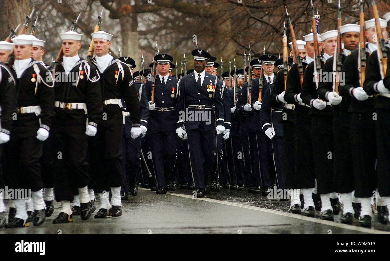 I membri dell'U.S. Forze Guardia d'onore marzo durante il funerale per pensionati Adm. Thomas H. Moorer il 20 febbraio 2004, presso l'Arlington Cimitero Nazionale. Adm. Moorer si è laureato presso l' Accademia navale classe di1933 ed è andato a servire come il capo di operazioni navali da 1967-1970, dopodiché è stato nominato Presidente del Comune di capi di Stato Maggiore, un incarico che ha mantenuto fino al suo pensionamento nel 1974. Un ex aviatore Navale, Moorer guadagnato molte decorazioni personali e riconoscimenti nel corso della sua carriera, tra cui il Dipartimento della Difesa di servizio distinto e Medaglia di illustri battenti croce. (UPI Photo/ Foto Stock