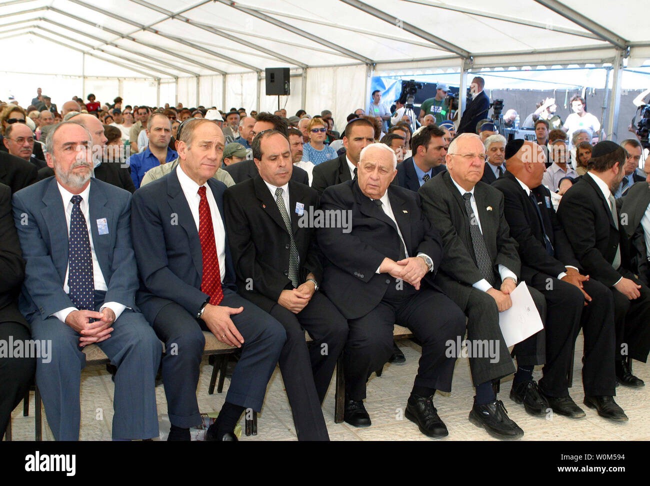 Il primo ministro Israeliano Ariel Sharon, centro assiste una cerimonia Giorno Memoriale della vigilia a un soldato' memorial a Gerusalemme domenica 25 aprile, 2004. Israele domenica ha iniziato osservando la sua annuale Giornata commemorativa per i soldati e civili uccisi in 144 anni di conflitto tra ebrei e arabi, poiché gli ebrei ha iniziato la sedimentazione di quello che ora è Israele. Seduto a destra è il sindaco di Gerusalemme Uri Lupolianski, Knesset Speaker Reuven Rivlin, la terza a destra e vice premier Ehud Olmert, seconda a sinistra. Altri sono non identificati. (UPI foto/Isaac Harari, piscina) Foto Stock