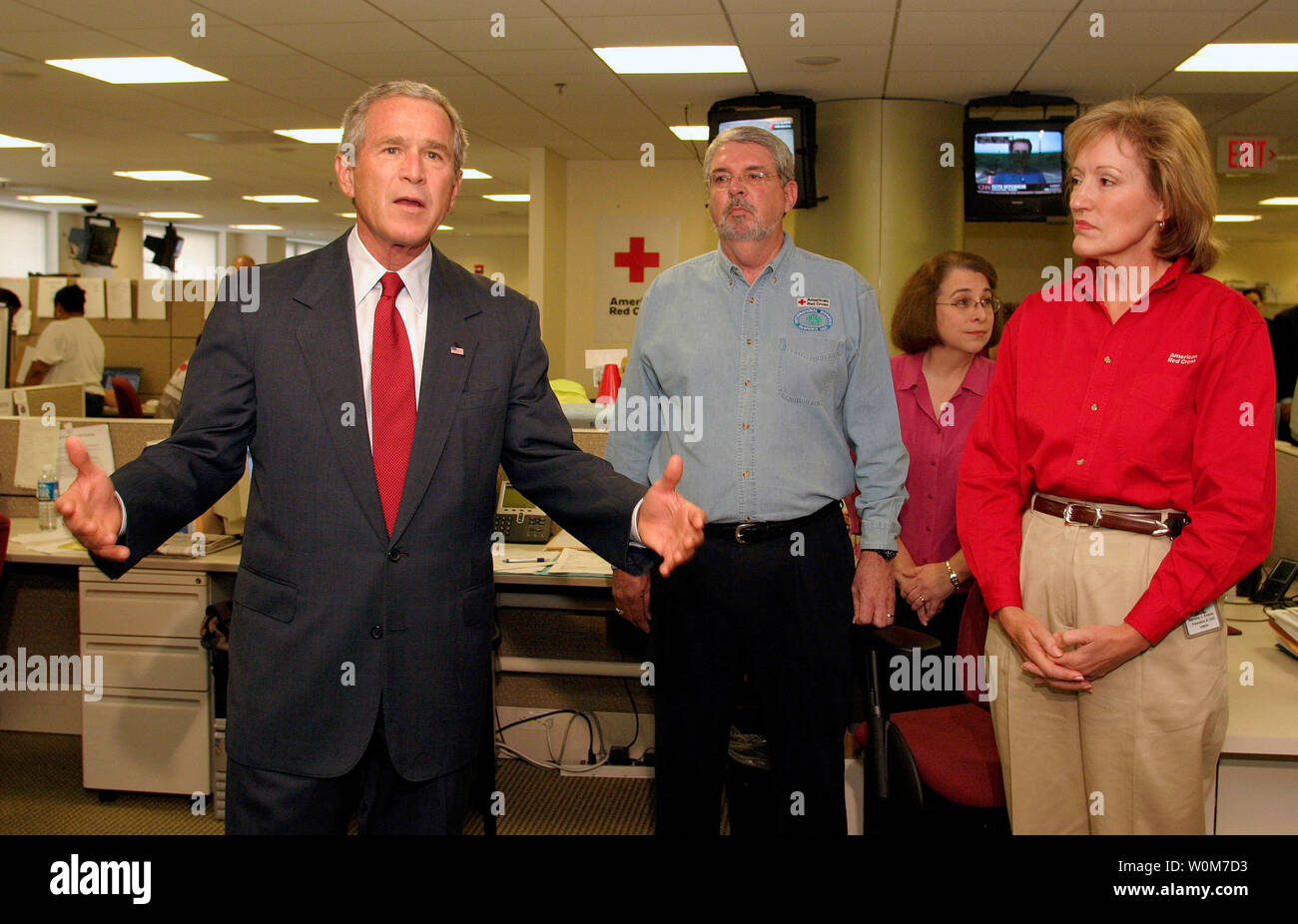 Stati Uniti Il Presidente George W Bush fa un appello per le donazioni durante una visita alla Croce Rossa Americana di Command Center di Washington D.C., il 4 settembre 2005. A destra sono la Croce Rossa il Presidente e CEO di Marty Evans (maglietta rossa) e Vice Presidente Esecutivo di capitolo e le operazioni internazionali, Alan McCurry. (UPI foto/Martin H. Simon) Foto Stock