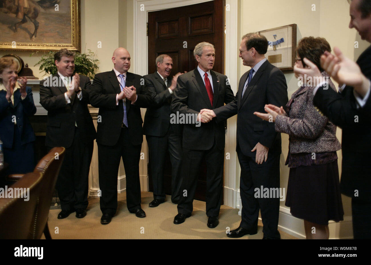 Il Presidente George W Bush stringe la mano con il giudice Samuel A. Alito nella sala Roosevelt della Casa Bianca Martedì, Gennaio 31, 2006, dopo che il senato ha votato per confermare il giudice Alito come il centodecimo della Corte suprema. Guardando da sinistra sono: Harriet Miers, Consigliere del Presidente; Bill Kelley, Vice Avvocato al Presidente; Steve Schmidt, Vice Assistente del Presidente ed ex senatore Dan Coats (R-ind.). A destra sono la Sig.ra Marta Ann Alito ed Ed Gillespie. (UPI foto/Eric Draper/Casa bianca) Foto Stock