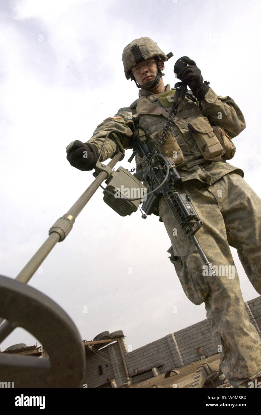 Army Spc. Joe Browning utilizza un rivelatore di metalli per cercare armi sepolta la cache e i materiali usati per la costruzione di ordigni esplosivi artigianali durante una pattuglia di vicinato a Mosul, Iraq, il 18 marzo 2006. (UPI foto/John M. Foster/USAF) Foto Stock