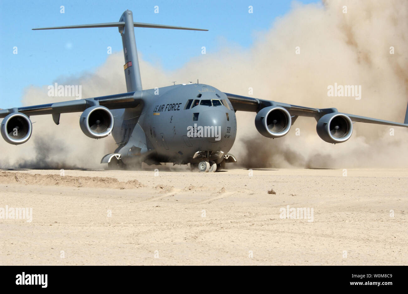 I motori a getto di una Forza Aerea C-17 Globemaster III kick up di nubi di polvere come il velivolo gira intorno alla fine di una pista di sporcizia, a bicicletta Lago Army Airfield in Fort Irwin, la California il 10 febbraio 2006. UPI foto/Sgt. Joe Zuccaro/DoD/File) Foto Stock
