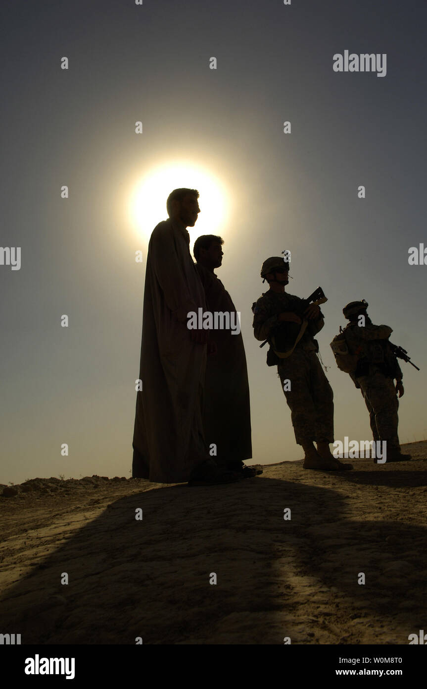 I cittadini iracheni guarda su come membri dell'U.S. Dell'esercito la B Company, 4-23 Reggimento di Fanteria, 172nd Stryker Brigade Combat Team, cerca veicoli durante un'antenna traffico punto di controllo missione vicino a Tall Afar, Iraq, lunedì 5 giugno 2006. (UPI foto/Giacobbe N. Bailey/STATI UNITI Air Force) Foto Stock