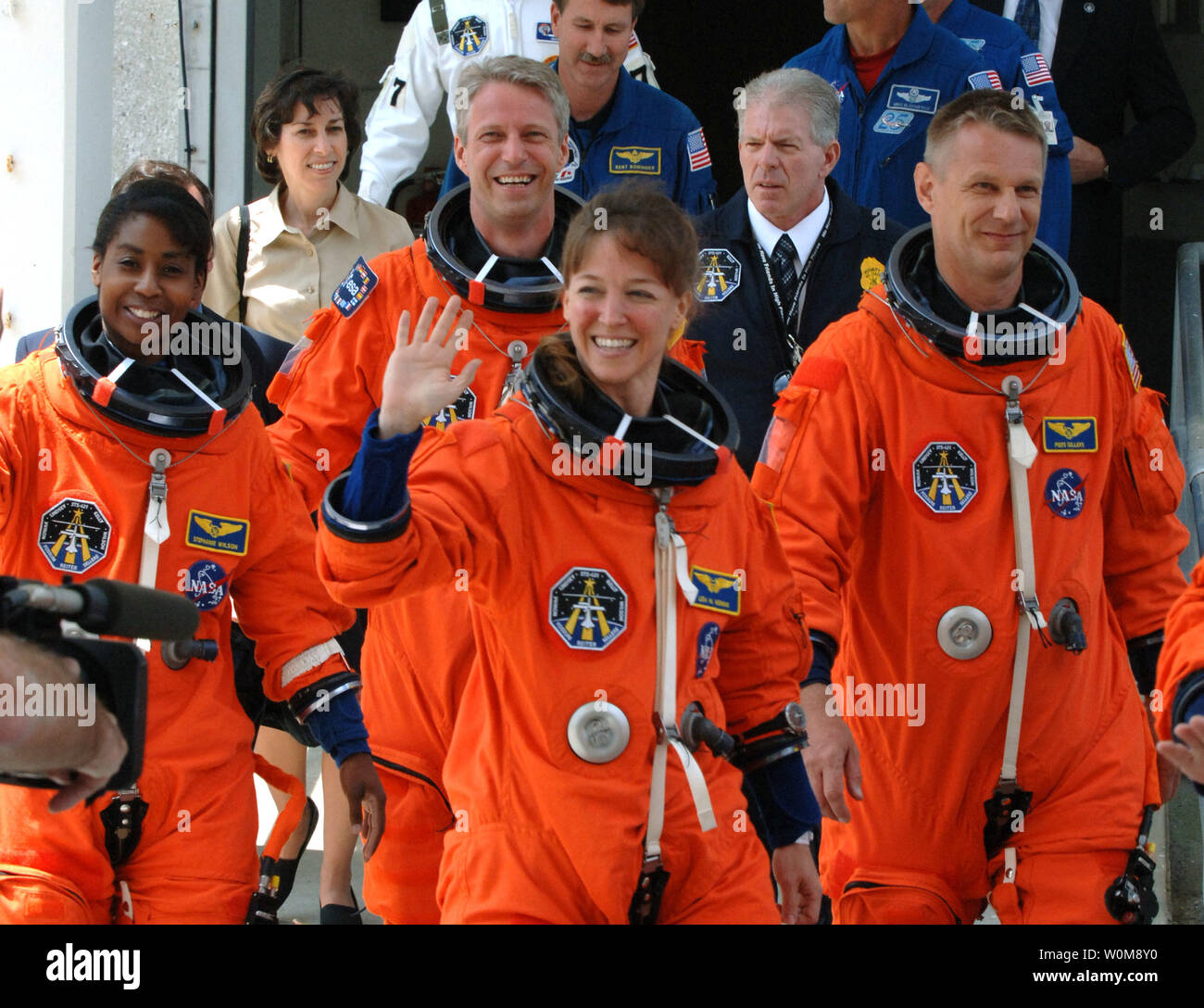 Astronauta missione specialisti Lisa Nowak (C), onde come lei cammina fuori con Stephanie Wilson (L), Piers venditori di Inghilterra (R) e Thomas Reiter (posteriore) della Germania, dalle operazioni e Checkout edificio a bordo della NASA Astrovan a bordo della navetta spaziale Discovery per la missione STS-121 a Cape Canaveral, in Florida il 1 luglio 2006. (UPI foto/Pat Benic) Foto Stock