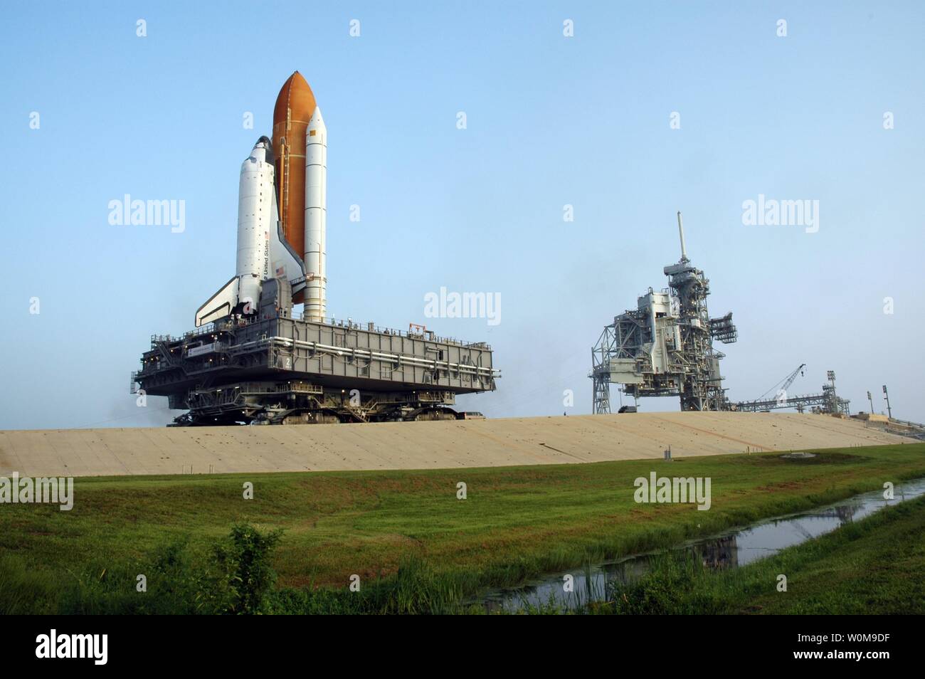 Infine sotto la luce del giorno, lo Space Shuttle Atlantis si avvicina il supporto rigido sulla rampa di lancio 39B al Kennedy Space Center il 2 agosto 2006. Il primo movimento al di fuori del gruppo del veicolo edificio è stato 1:05 a.m. La navetta si trova nella parte superiore del mobile piattaforma di lancio, che a sua volta appoggia su il crawler-transporter. La velocità lenta del cingolato risultati in un 6 ore di trek per il pad a circa 4 miglia di distanza. Atlantis' finestra di lancio inizia il agosto 27 per 11 giorni di missione alla stazione spaziale internazionale. Il servizio STS-115 equipaggio di sei astronauti continuerà la costruzione della stazione e installare il loro carg Foto Stock