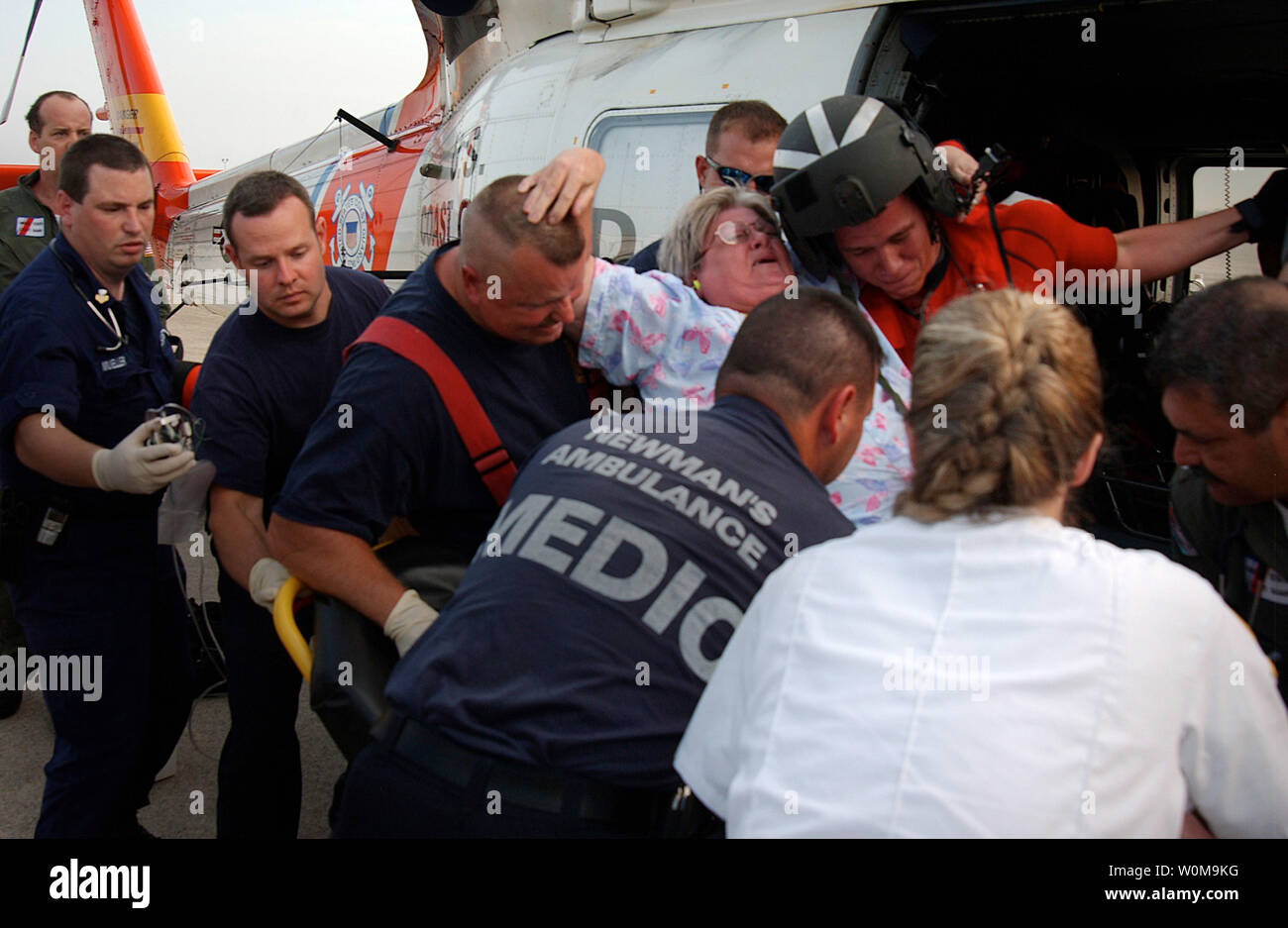 Una guardia costiera elicottero di salvataggio e di equipaggio paramedico da Mobile zona assistere una donna su una barella presso la Guardia costiera in base Mobile, AL 1 SETTEMBRE 2005. Pazienti criticamente malati da un Biloxi Guardia Nazionale ospedale da campo sono state trasportate dalla Coast Guard base e trasferito a EMS locale. (UPI foto/NyxoLyno Cangemi/USCG) Foto Stock