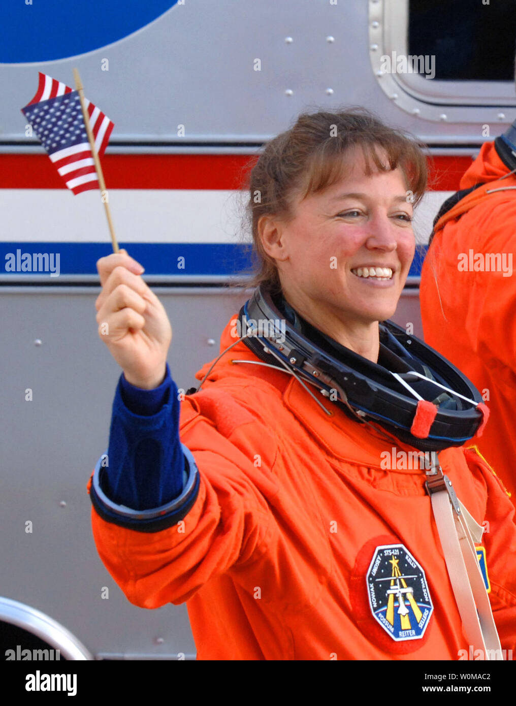Astronauta Lisa Nowak è stato caricato con il tentato omicidio di primo grado e il 6 febbraio 2007. La polizia dice che Nowak ha spinto 900 miglia e indossato un travestimento prima di fronte a una donna che ha creduto era un concorrente per le affezioni del Navy Cmdr. William Oefelein, un celibe compagno astronauta. Nowak è mostrato sventola una bandiera americana come ha camminato fuori delle operazioni e Checkout edificio a bordo della NASA Astrovan in rotta per la navetta spaziale Discovery per la missione STS-121 a Cape Canaveral, in Florida il 4 luglio 2006. (UPI foto/Pat Benic/File) Foto Stock