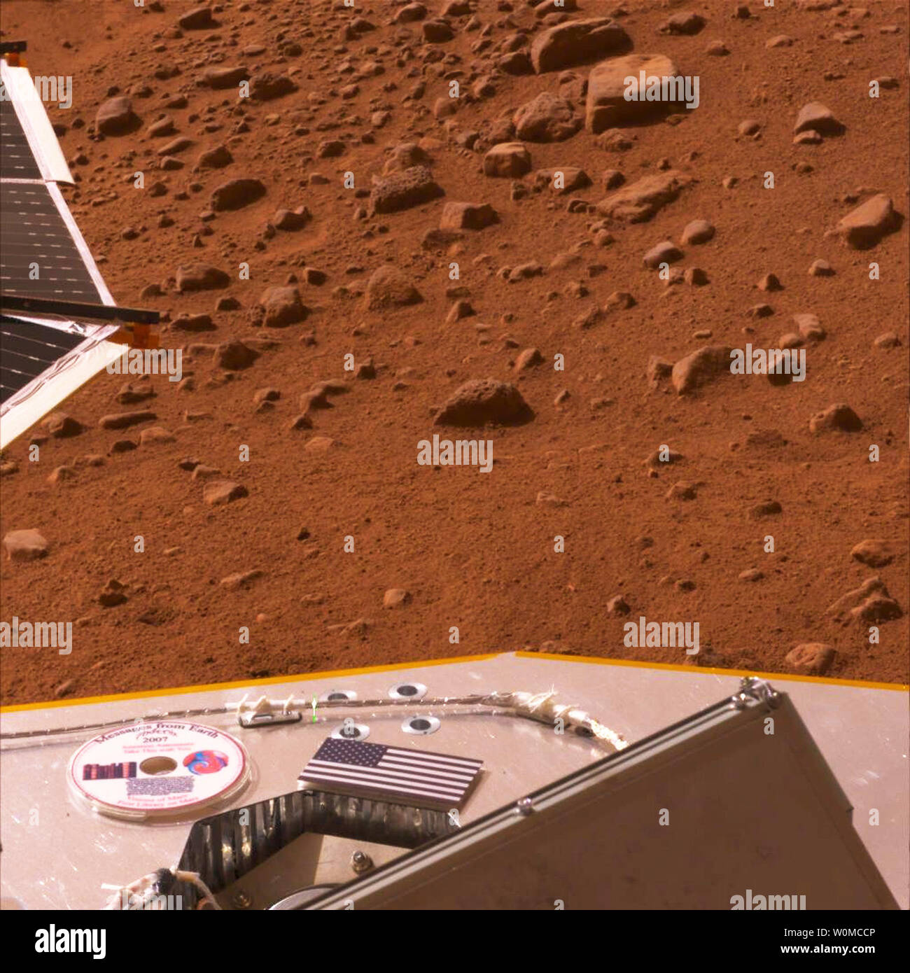 In questa immagine fornita dalla NASA, mostra il lander Phoenix con la bandiera americana e un mini-DVD sul ponte,circa 3 metri sopra la superficie di Marte il 26 maggio 2008. Il mini-DVD dalla società planetaria contiene un messaggio ai futuri esploratori marziano, storie fantascientifiche, arte ispirata dal pianeta rosso e i nomi di più di un quarto di milione di terrestri. Phoenix atterrato sul Pianeta rosso a 7:53 p.m. Tempo orientali, 25 maggio 2008, in una regione artica chiamato Vastitas Borealis, a 68 gradi di latitudine nord, 234 gradi di longitudine est. (UPI foto/NASA/JPL-Caltech/University of Arizona) Foto Stock