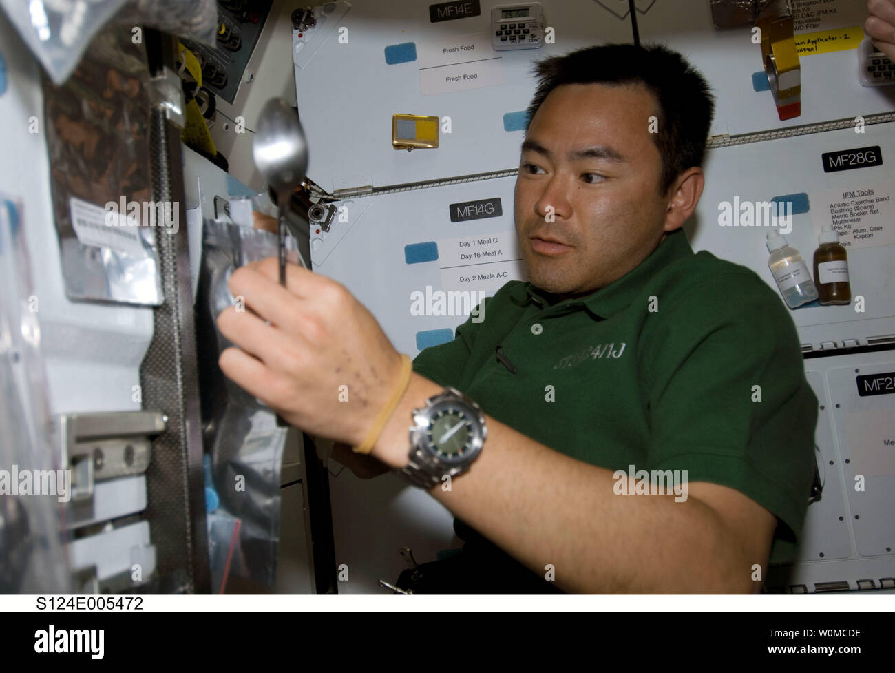 Japan Aerospace Exploration Agency (JAXA) astronauta Akihiko Hoshide, STS-124 lo specialista di missione, si appresta a mangiare un pasto presso la cucina del middeck della navetta spaziale Discovery il 1 giugno 2008. (UPI foto/NASA) Foto Stock