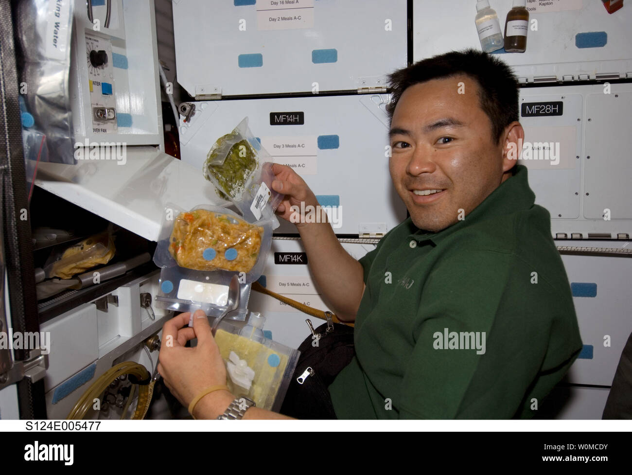 Japan Aerospace Exploration Agency (JAXA) astronauta Akihiko Hoshide, STS-124 lo specialista di missione, si appresta a mangiare un pasto presso la cucina del middeck della navetta spaziale Discovery il 1 giugno 2008. (UPI foto/NASA) Foto Stock