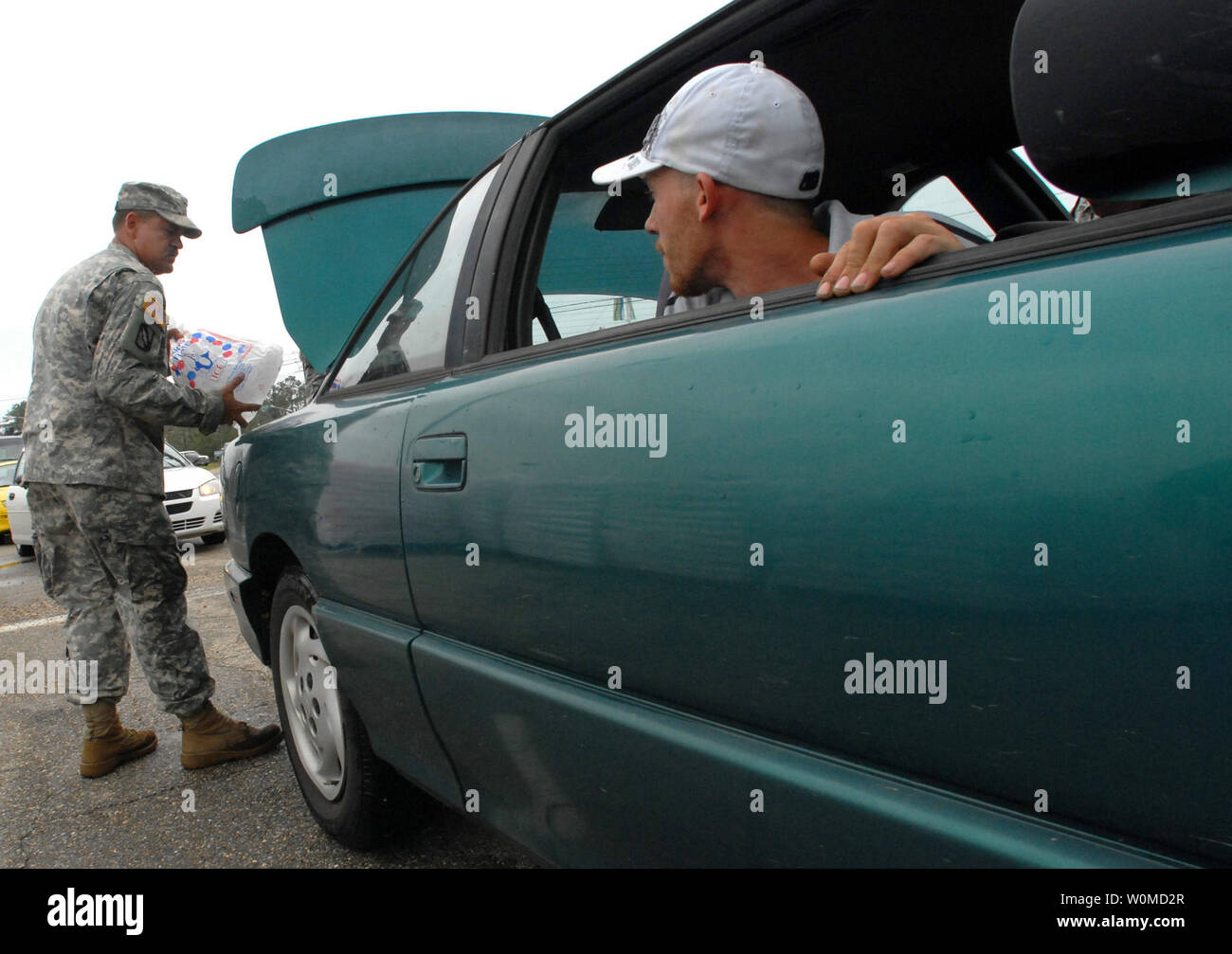 Un ritorno Gulfport, Mississippi evacuee orologi come esercito Spc. David Kennedy, del Mississippi esercito Guardia Nazionale pone una borsa di ghiaccio nella sua automobile in corrispondenza di un punto di distribuzione appena fuori di Gulfport il 2 settembre 2008. Cittadini iniziato il rientro di ieri dopo l'uragano Gustav impone una evacuazione dell'area. (UPI foto/Michael J. Carden/DOD) Foto Stock