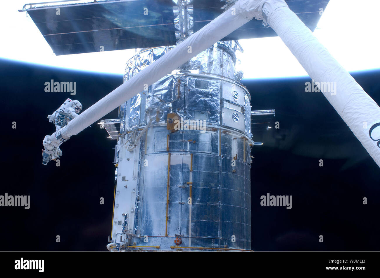 Astronauta John Grunsfeld, posizionata su di un piede sulla ritenuta alla fine di Atlantide' remoto sistema di manipolatore, ha partecipato alla missione di quinta e ultima spacewalk come sono proseguiti i lavori per rinnovare e aggiornare il telescopio spaziale Hubble il 18 maggio 2009. Durante sette ore spacewalk, Grunsfeld e astronauta Andrew Feustel (al di fuori del frame) installato un gruppo batteria di ricambio rimosso e sostituito una multa di orientamento sensore e tre coperte termiche che proteggere Hubble's Electronics. L'Atlantis equipaggio ha detto addio a Hubble, dopo aver completato i loro lavori di riparazione su 19 Maggio, 2009. (UPI foto/NASA) Foto Stock