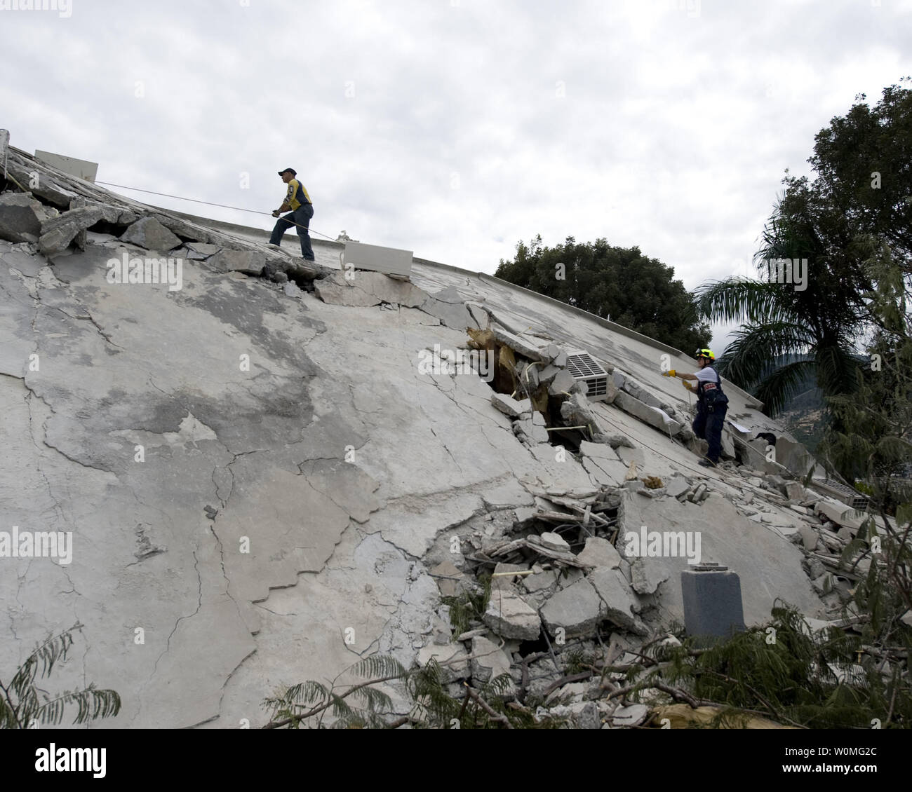 I membri di Fairfax County ricerca e salvataggio in aree urbane di scala è crollata una sezione dell'Hotel Montana su gennaio 14, 2010 a Port-au-Prince, Haiti durante una ricerca per i superstiti di un terremoto di magnitudine 7.0. 8 persone di cui 7 americani sono stati liberati dalle macerie dell'hotel. UPI/Joshua Lee Kelsey/STATI UNITI Navy. Foto Stock