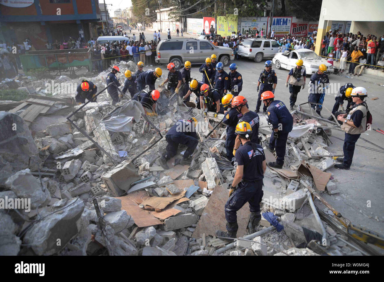 Membri del Los Angeles County Fire Department di ricerca e salvataggio della squadra per eliminare detriti in corrispondenza di un edificio crollato nel centro di Port-au-Prince, Haiti, il 17 gennaio, 2010. Parte-au-Prince è stato colpito da un devastante terremoto di magnitudine 7.0 a gennaio 12, 2010. UPI/Justin Stumberg/US Navy Foto Stock