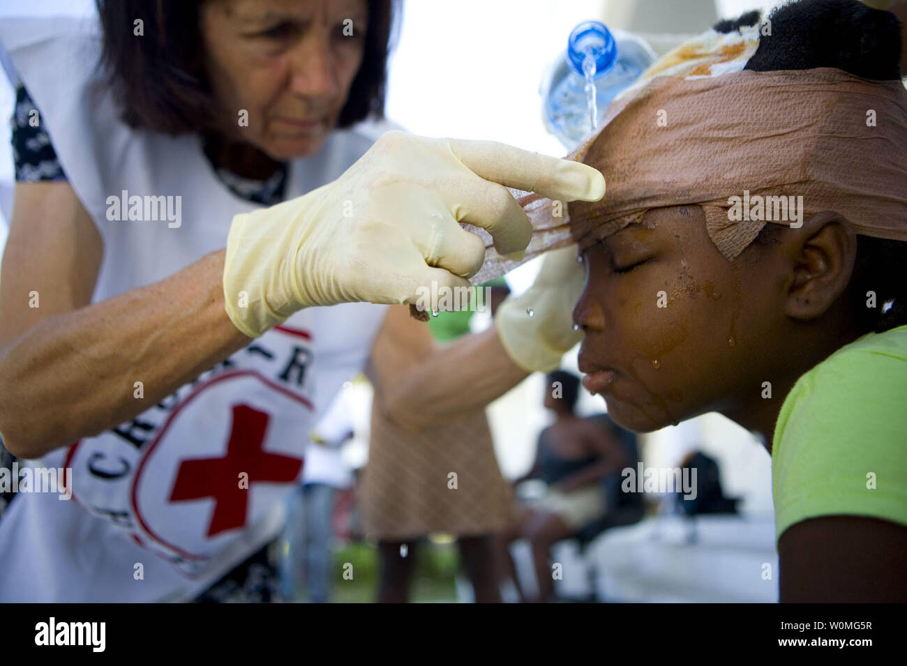 Canadian Red Cross nurse Suzanne Puzo bende rimuove il 10-anno-vecchio Danise divergono in Croix Desprez a Port-au-Prince, Haiti il 18 gennaio 2010. Un terremoto di magnitudine 7.0 ha colpito Haiti il 12 gennaio, devastando la capitale del paese e città circostanti. UPI/Talia Frenkel/la Croce Rossa americana Foto Stock