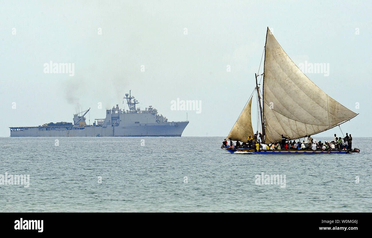 Un Haitian vele di imbarcazioni al largo della costa di Haiti il 19 gennaio 2010 come il dock anfibio sbarco nave USS Carter Hall (LSD 50) opera in distanza. Carter Hall è il supporto di funzionamento risposta unitaria, un' operazione congiunta la fornitura di assistenza umanitaria a seguito di un terremoto di magnitudine 7.0 che ha devastato la nazione insulare Gen 12, 2010. UPI/Kristopher Wilson/STATI UNITI Navy Foto Stock