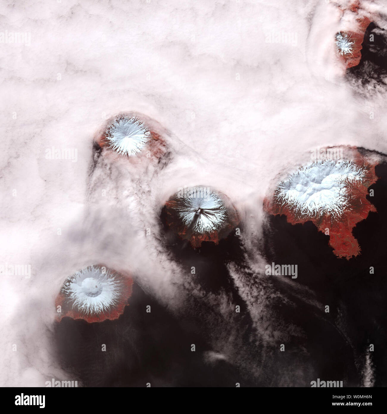 Questa immagine della NASA rilasciato nel mese di agosto 2010 prese dalla telecamera ASTER a bordo della NASA in orbita satellitare Terra mostra le cime innevate dei vulcani che compongono le isole delle quattro montagne in Alaska di Isola Aleutian catena. UPI/NASA Foto Stock