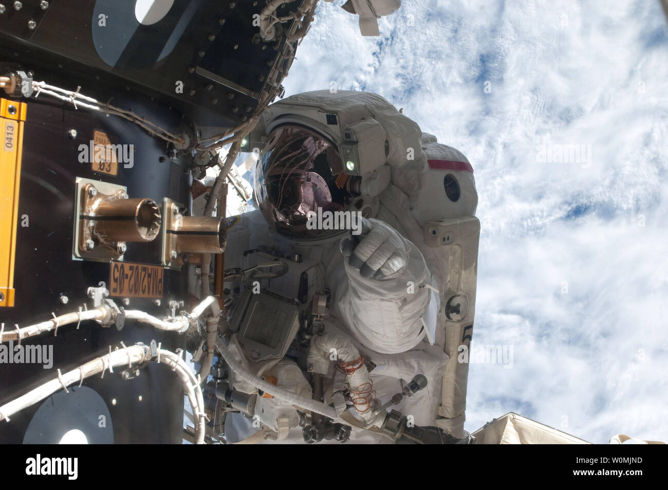 Questa immagine della NASA prese sulla luglio 12, 2011 mostra l'astronauta della NASA Mike Fossum, Expedition 28 tecnico di volo, come egli attende in corrispondenza di una stazione spaziale internazionale è pressurizzato adattatore di accoppiamento (PMA-2) collegato con la navetta spaziale Atlantis, così come la stazione del sistema robotico si muove la pompa guasta modulo (al di fuori del frame) oltre al spacewalking astronauta e stiva dello shuttle. Fossum e crewmate Ron Garan inviato sei ore e 31 minuti sul loro Luglio 12 spacewalk. Lo Space Shuttle Atlantis è presso la Stazione Spaziale Internazionale sulla missione STS-135, l'ultima missione shuttle. UPI/NASA Foto Stock