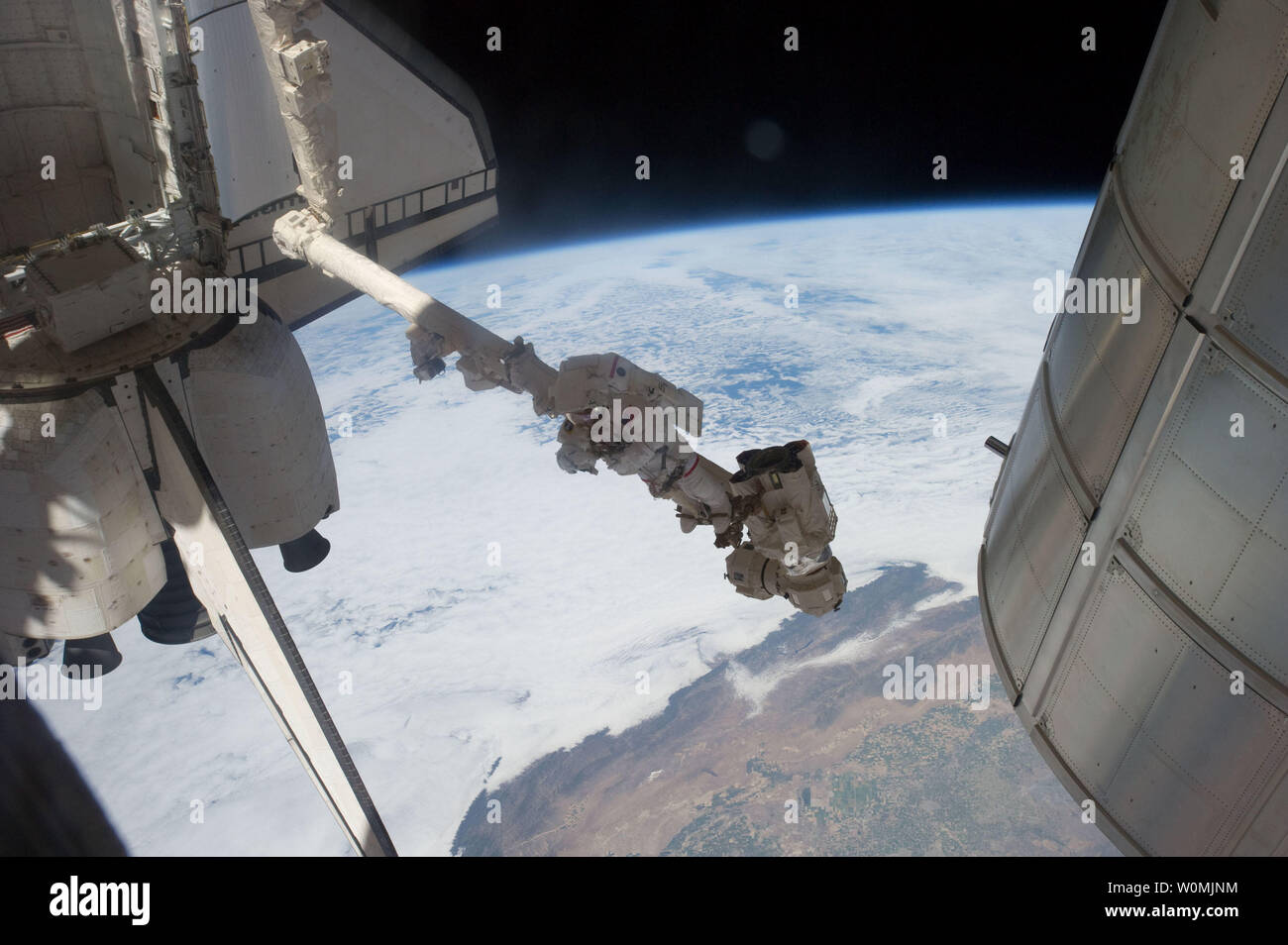 Questa immagine della NASA prese sulla luglio 12, 2011 mostra l'astronauta della NASA Mike Fossum, Expedition 28 tecnico di volo, sospesa dalla fine della stazione di spazio remoto sistema di manipolatore durante un periodo di sei ore e mezza di spacewalk. Lo Space Shuttle Atlantis è presso la Stazione Spaziale Internazionale sulla missione STS-135, l'ultima missione shuttle. UPI/NASA Foto Stock