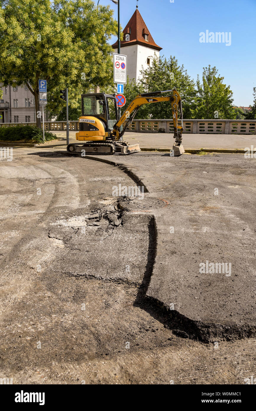 Praga, Repubblica ceca - Luglio 2018: Mini escavatore su una strada nel centro di Praga con la superficie stradale rimosso Foto Stock