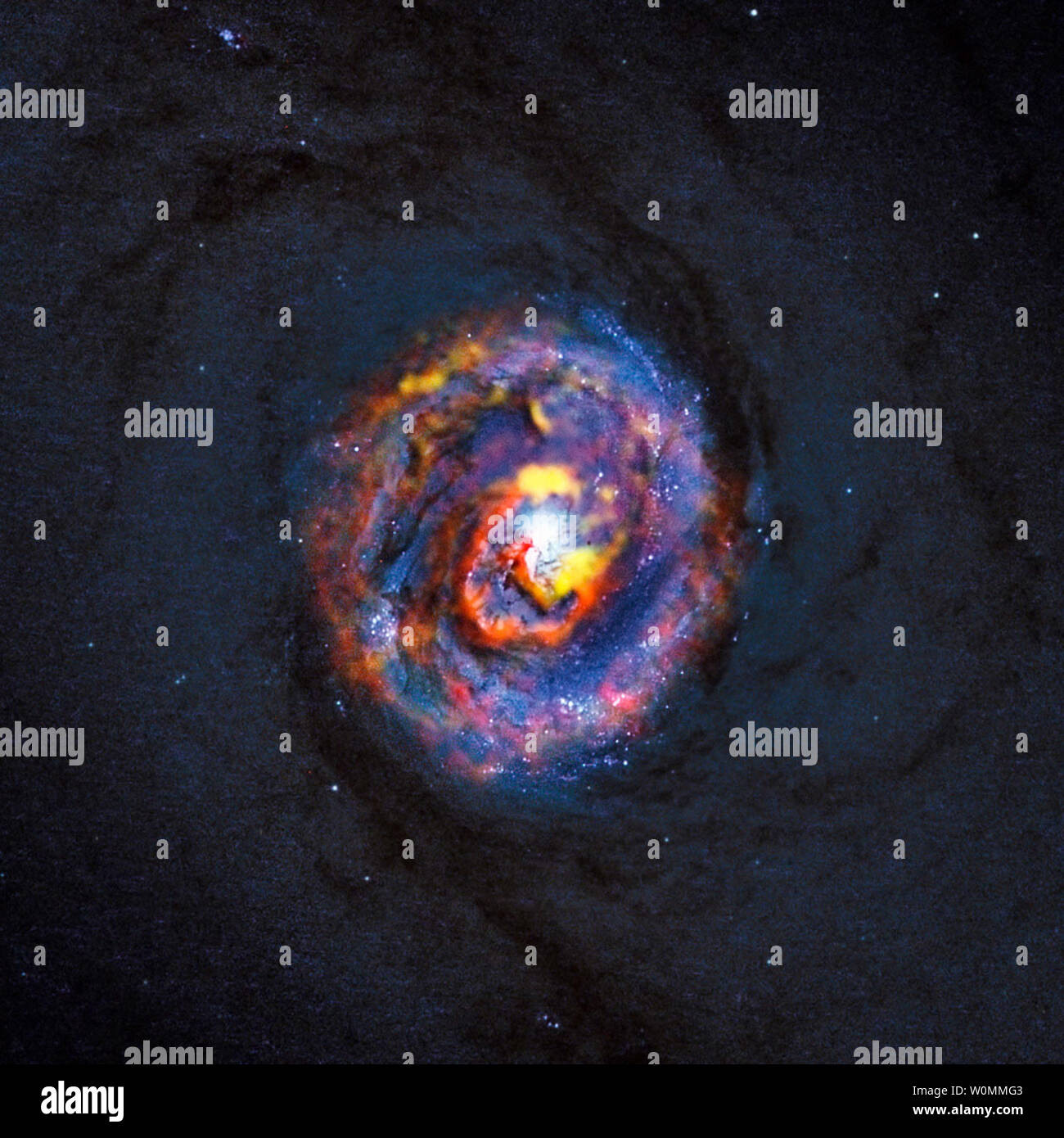 Foto rilasciata il 16 ottobre 2013 dall'Osservatorio europeo australe (ESO) mostrano come un buco nero consuma enormi quantità di materia in studi pubblicati sulla galassia PKS e 1830-211 NGC 1433. Questa foto mostra NGC 1433 in un composito immagine -- dim blue immagine di sfondo che mostra il centro di vicoli di polvere di questa galassia proviene dalla NASA/ESA Telescopio Spaziale Hubble e le strutture colorate vicino al centro sono da recenti ALMA (Atacama Large Millimeter/Array submillimetrico) osservazioni che hanno rivelato una forma a spirale, come pure un inaspettato deflusso, per la prima volta. Questo spiega come t Foto Stock