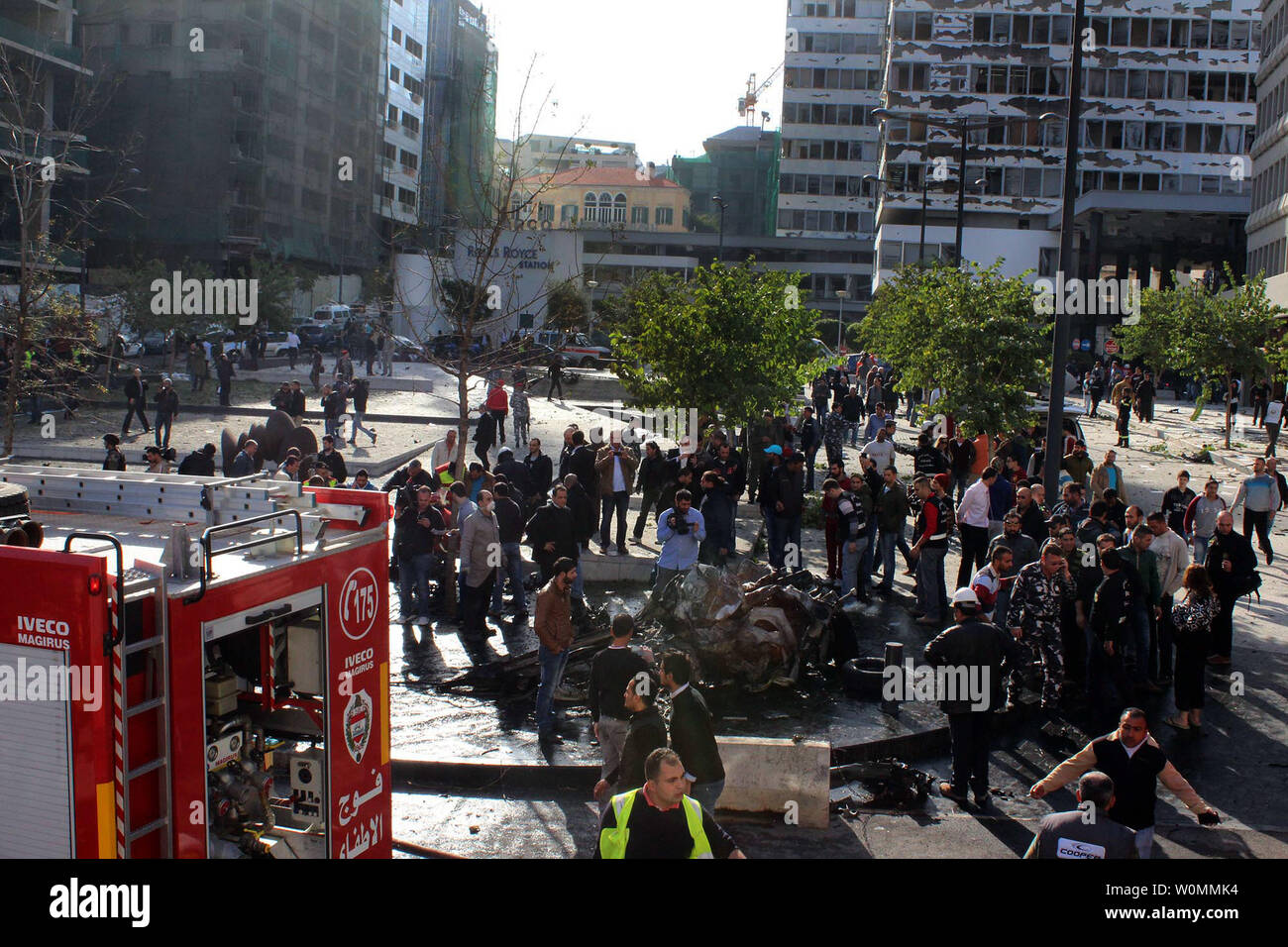 I funzionari e i civili si riuniranno presso il sito di un'esplosione nel centro cittadino di Beirut che ha ucciso almeno cinque persone, inclusi gli ex ministro libanese Mohamad Chatah, il 27 dicembre 2013. Chatah, chi è un accanito oppositore del Presidente siriano Bashar al-Assad, è stato ucciso in una massiccia esplosione che mirate il suo convoglio di auto. Più che 70 persone sono rimaste ferite. UPI/Mohamad Sultan Foto Stock
