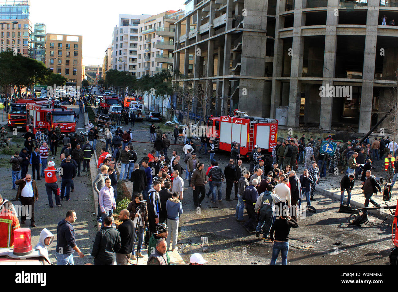 I funzionari e i civili si riuniranno presso il sito di un'esplosione nel centro cittadino di Beirut che ha ucciso almeno cinque persone, inclusi gli ex ministro libanese Mohamad Chatah, il 27 dicembre 2013. Chatah, chi è un accanito oppositore del Presidente siriano Bashar al-Assad, è stato ucciso in una massiccia esplosione che mirate il suo convoglio di auto. Più che 70 persone sono rimaste ferite. UPI/Mohamad Sultan Foto Stock