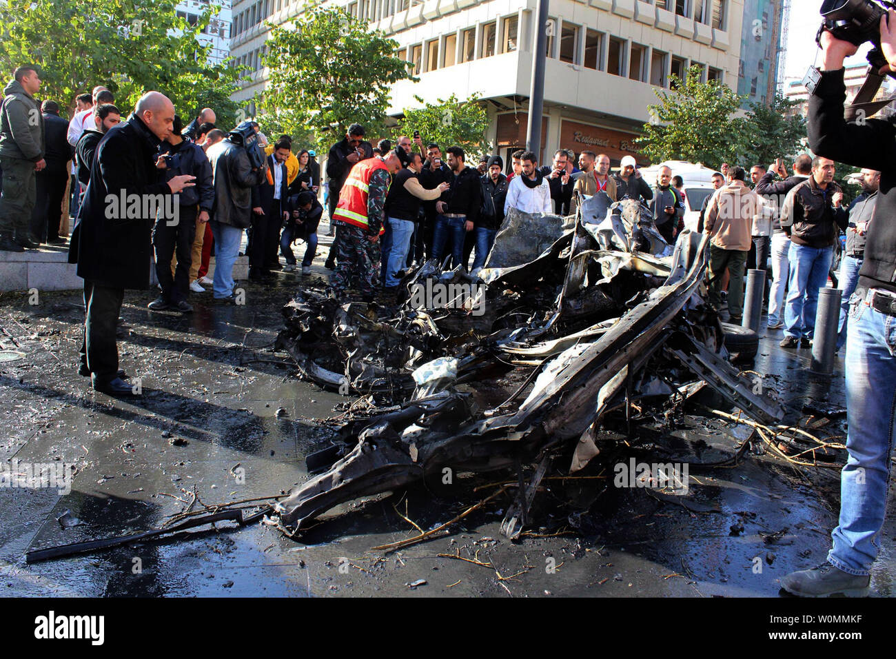 I funzionari e i civili si riuniranno presso il sito di un'esplosione nel centro cittadino di Beirut che ha ucciso almeno cinque persone, inclusi gli ex ministro libanese Mohamad Chatah, il 27 dicembre 2013. Chatah, chi è un accanito oppositore del Presidente siriano Bashar al-Assad, è stato ucciso in una massiccia esplosione che mirate il suo convoglio di auto. Più che 70 persone sono rimaste ferite. UPI/Mohamad Sultan Foto Stock