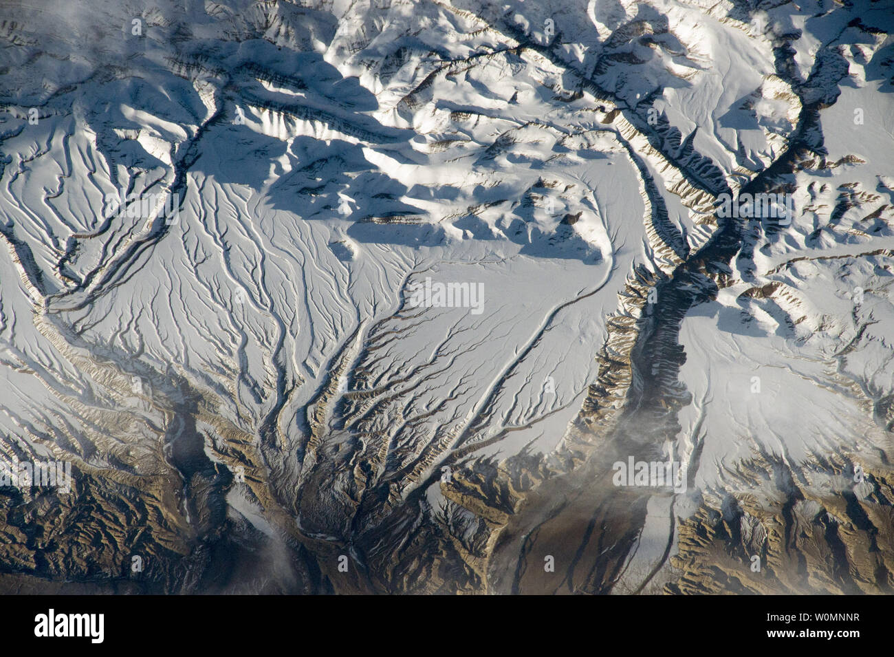 Questa immagine obliqua è stata adottata il 8 aprile 2015 dalla Stazione Spaziale Internazionale come gli astronauti volato oltre l'Himalaya gamma in Cina vicino al confine indiano. La vista mostra uno dei principali campi di Himalaya montagne attraverso la parte inferiore dell'immagine, dove i picchi cast forti ombre della sera contro la neve. I picchi raggiungono grandi altitudini (5200 m, 17.000 piedi), con quelli appena al di fuori del margine inferiore di raggiungere abbastanza alta (6500 m, 21,325 piedi) per ospitare i ghiacciai. La NASA/UPI Foto Stock