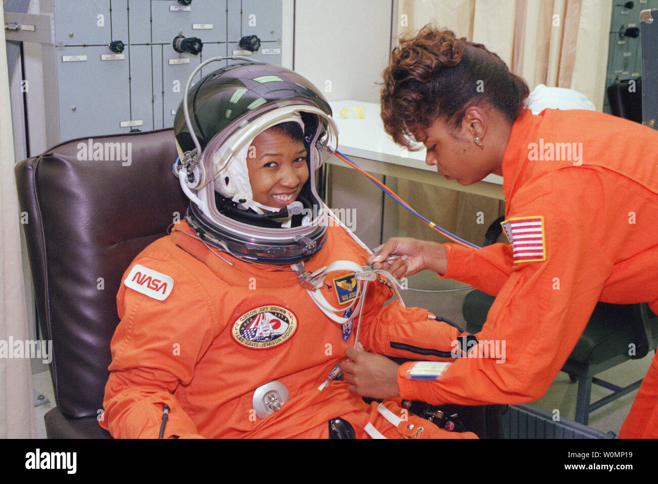 Il 12 settembre 1992, giorno del lancio di STS-47 Spacelab-J missione sullo Space Shuttle Endeavour, astronauta della NASA Mae Jemison attende come la sua tuta tecnico, Sharon McDougle, esegue un depressurizzato e la perdita di pressione controllare sulla sua tuta spaziale a operazioni e acquista la costruzione presso il Kennedy Space Center. Il dottor Jemison era la scienza lo specialista di missione su otto giorni di missione congiunta con il Giappone space agency, che includeva 24 scienza dei materiali e 20 scienze della vita esperimenti. Lei è stata la prima donna afro-americana a volare nello spazio. McDougle detto del suo ruolo come il dottor Jemison la tuta tech, 'ho appena wa Foto Stock