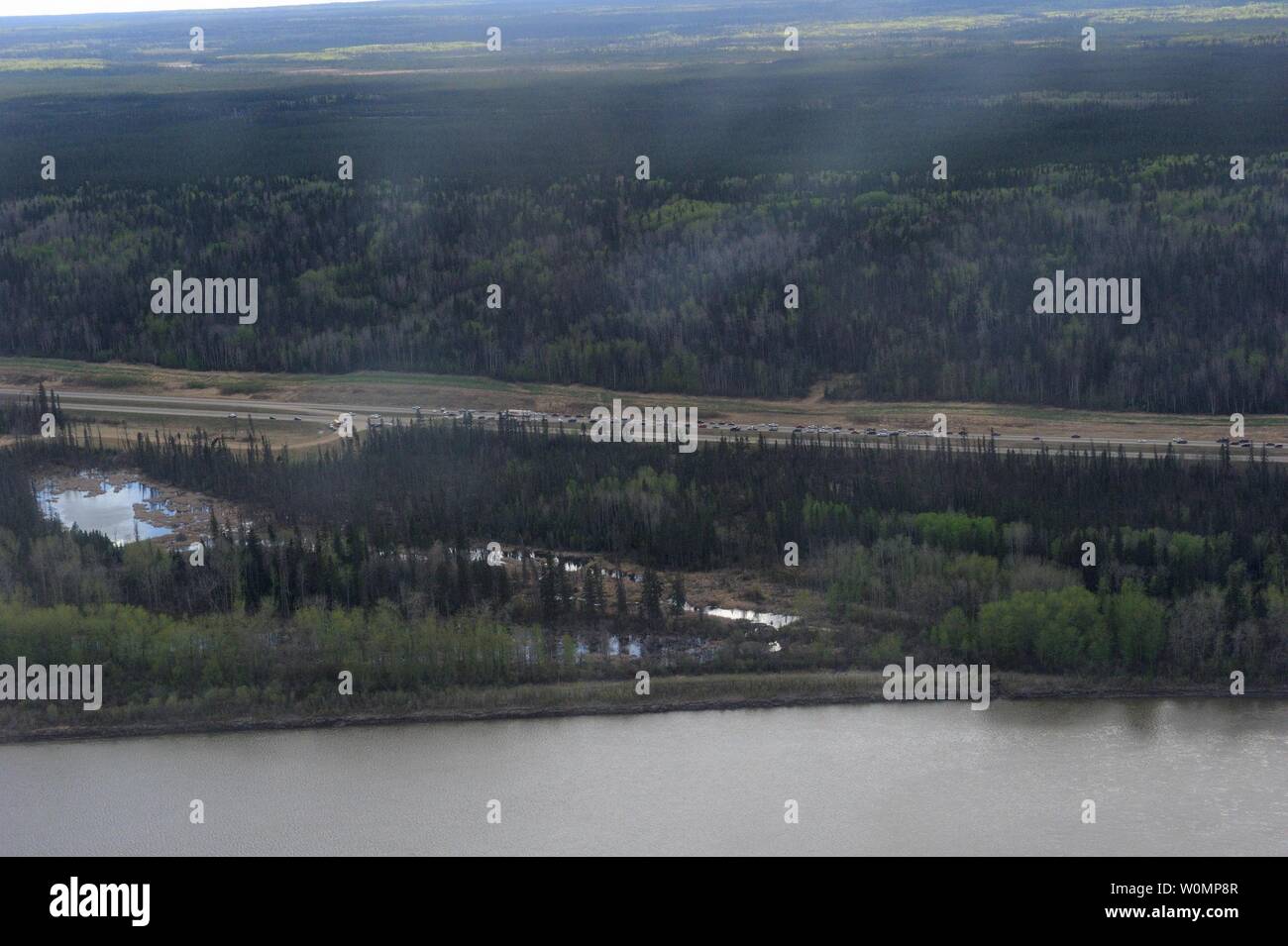 Vista aerea dell'autostrada 63 sud di Fort McMurray, presi da un CH-146 Griffon elicottero il 5 maggio 2016. Le forze armate canadesi hanno aria beni impiegati nel supporto della provincia di Alberta's wildfire di risposta di emergenza sforzi. Al momento questa immagine è stata scattata una evacuazione obbligatoria era stata collocata su tutti di Fort McMurray - la più grande evacuazione su record in Canada. Il fuoco aveva bruciato attraverso quasi 77 chilometri quadrati, radendo i quartieri della città. Foto di MCpl VanPutten/Forze armate canadesi/UPI Foto Stock