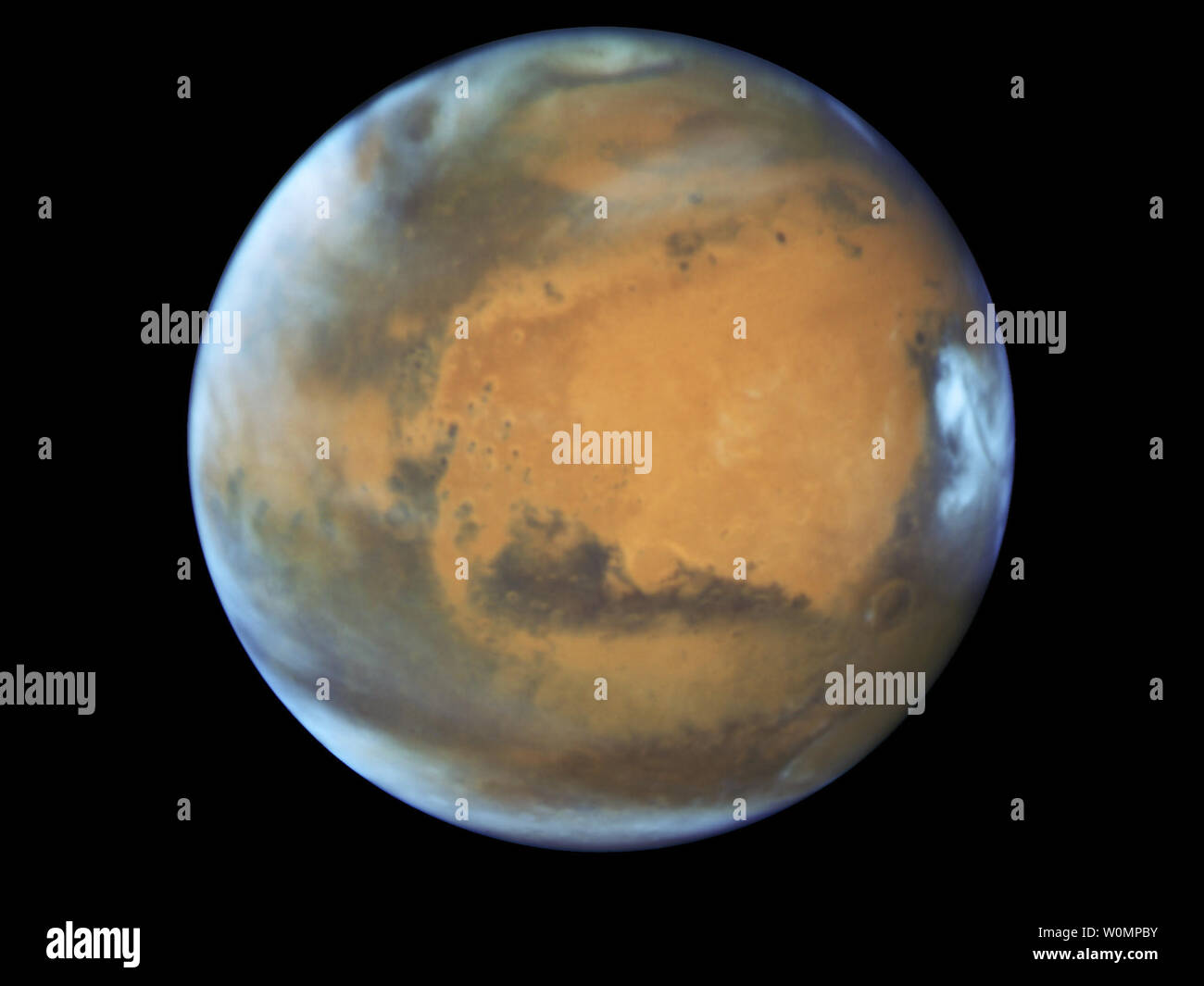 Questa immagine mostra il nostro vicino pianeta Marte, come si è osservato poco prima di opposizione nel 2016 dalla NASA/ESA Telescopio Spaziale Hubble. Alcune importanti caratteristiche del pianeta sono chiaramente visibili: gli antichi e inattivo vulcano a scudo Syrtis principali; la luminosa e ovale Hellas Planitia basin; la pesantemente eroso Arabia Terra nel centro dell'immagine; il buio caratteristiche di Sabaeous sinusale e Meridiani Sinus lungo l'equatore e la piccola sud della calotta polare. La NASA/UPI Foto Stock