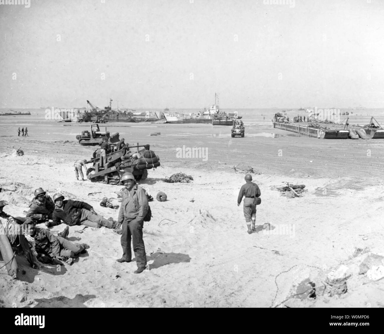 Scena su una delle spiagge di invasione, forza durante le operazioni di accumulo nel giugno 1944. Nota: Shore parte rilassante (primo piano a sinistra); Bulldozer con parafanghi pesante sulla sua lama, eventualmente per le imbarcazioni di salvataggio dei fini (dietro la riva partito); Spiaggiata sbarco navi, comprese (da sinistra a destra): USS LCT-852; British LCT-2302 e un Rhino (RHF) pontoon Inclus. Questa fotografia, prese da combattimento unità foto undici (CPU-11), è stato ricevuto dalla Marina Photo Science Laboratory il 3 luglio 1944. Foto di U.S. Navy/Archivi Nazionali/UPI Foto Stock