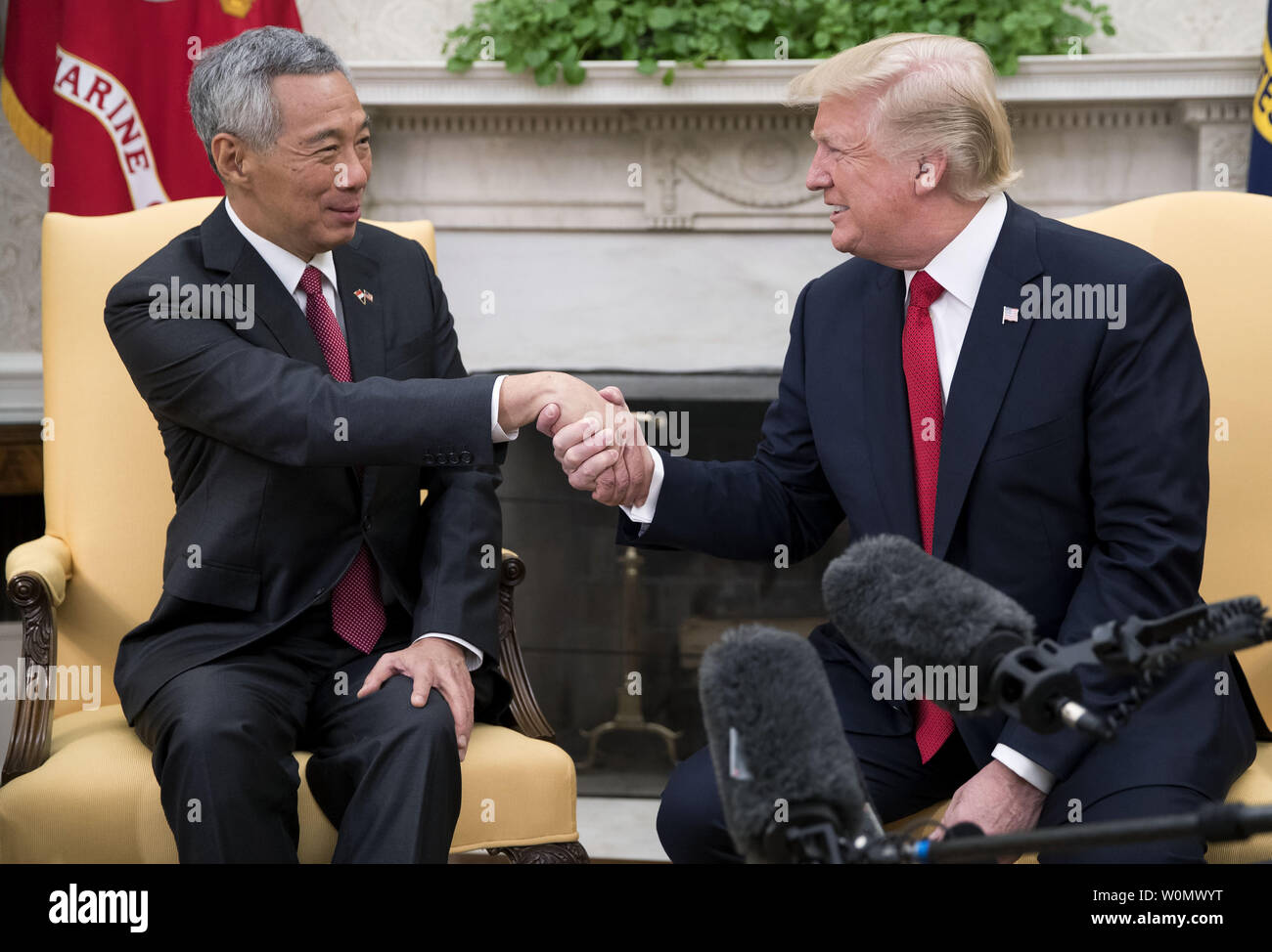 Stati Uniti Presidente Donald Trump (R) accoglie con favore il primo ministro Lee Hsien Loong (L) di Singapore all Ufficio Ovale prima di una serie di incontri tra i due alla Casa Bianca a Washington DC, il 23 ottobre 2017. L incontro avviene a meno di due settimane prima che il Presidente Trump fa un lungo viaggio per la regione Asia Pacifico. Foto di Shawn Thew/UPI Foto Stock