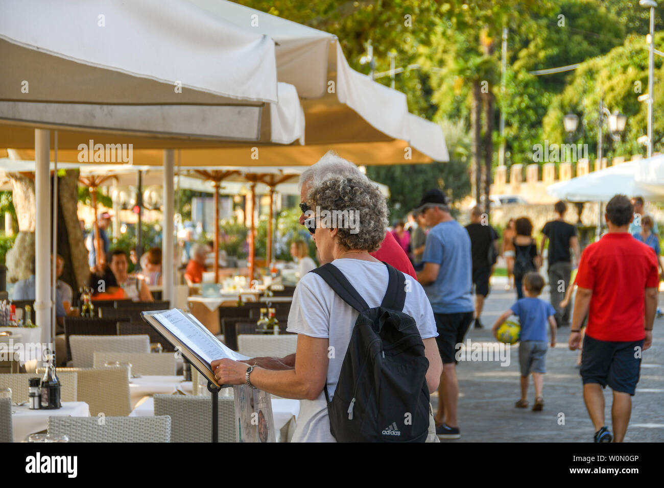 GARDA, Italia - Settembre 2018: due persone che studiano il menu di un ristorante sul lago di Garda sul Lago di Garda. Foto Stock