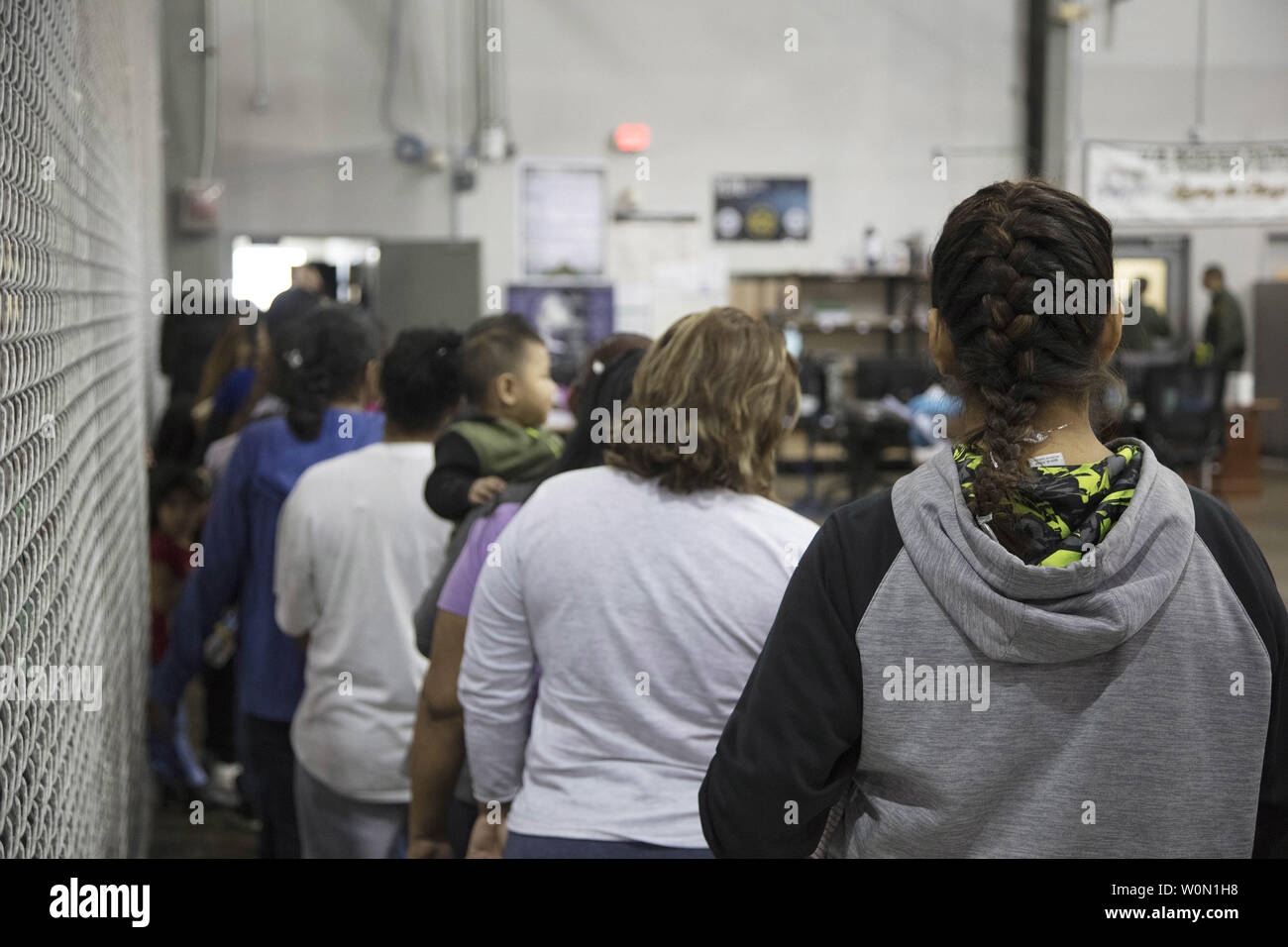 Persone che sono già stati presi in custodia legata a presunte ingresso illegale negli Stati Uniti di attendere in linea per essere trasformati presso l'U.S. Pattuglia di Confine Central Processing Center di McAllen, Texas, 17 giugno 2018. Foto di U.S. Pattuglia di Confine/UPI Foto Stock