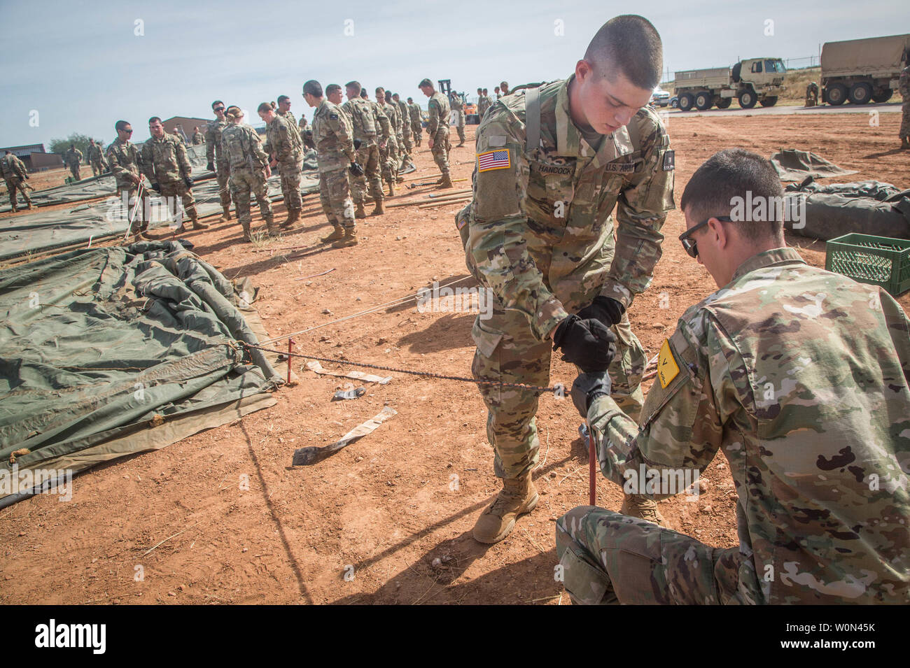 Stati Uniti I soldati dell esercito, assegnato alla 309th Intelligenza militare Battaglione e 305Intelligenza militare battaglione, lavora insieme al martello un picchetto nel terreno per mantenere la tenda stabile, sulla Fort Huachuca, Arizona, il 1 novembre 2018. Egli stava facendo questo per costruire un "tenda" della città che ospiterà numerosi soldati per funzionamento fedeli Patriot. Foto di Spc. Brandon migliori/STATI UNITI Esercito/UPI Foto Stock