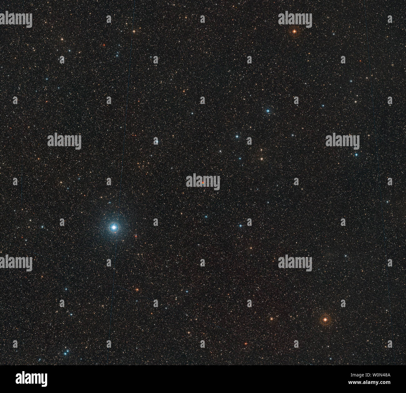 Questo ampio campo di immagine, rilasciato il 14 novembre 2018, mostra le frazioni del Red Dwarf noto come Barnard Star nella costellazione di Ofiuco (l'Serpent-Bearer). Questa immagine è stata creata a partire da materiale formante parte dell'digitalizzato Sky Survey 2. Il centro dell'immagine mostra Barnard Star catturato in tre diverse esposizioni. La stella è il più veloce lo spostamento stella nel cielo notturno e il suo ampio movimento apparente può essere visto come la sua posizione cambia tra successive osservazioni - mostrato in rosso, giallo e blu. Foto di ESO/UPI Foto Stock