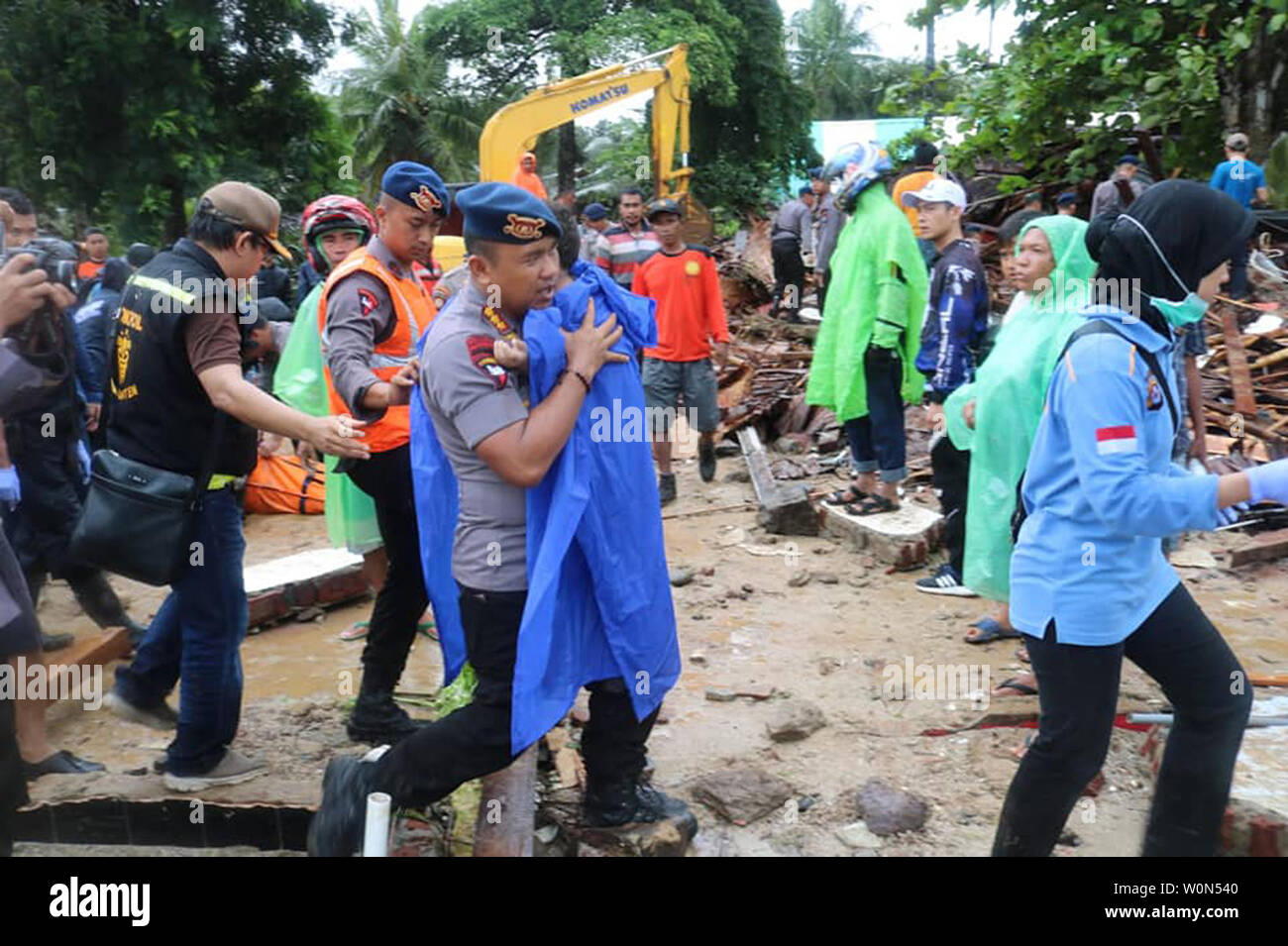 Un funzionario di polizia porta un ragazzo ferito, liberato dai resti di un hotel è crollato a seguito di un tsunami nella provincia di Banten, Indonesia, il 23 dicembre 2018. Secondo i funzionari locali, un sottomarino di frana a seguito di una eruzione di Anak Krakatau ha provocato uno tsunami che ha ucciso almeno 373 persone e il ferimento di centinaia sulle isole indonesiane di Giava e Sumatra. Foto di Banten Polizia/UPI Foto Stock