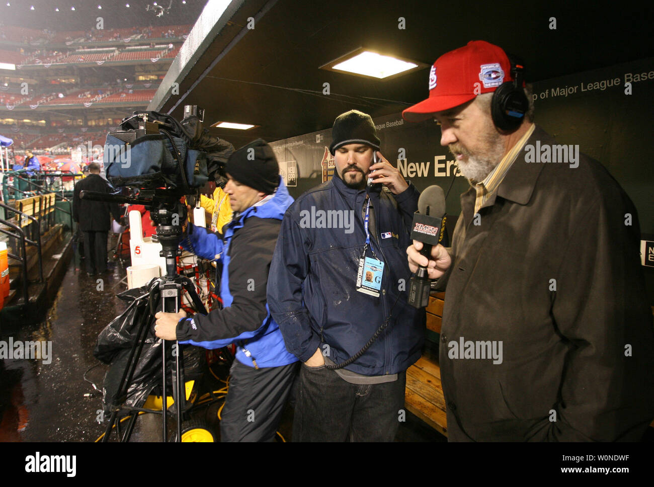 Ex St. Louis Cardinals pitcher e National Baseball Hall of Fame stati Bruce Sutter (R) prende il coperchio con altri elementi multimediali in piroga durante una intervista alla radio come una leggera pioggia cade il Busch Stadium forzando la cancellazione del gioco 4 del 2006 World Series a San Louis il 25 ottobre 2006. (UPI foto/Bill Greenblatt) Foto Stock