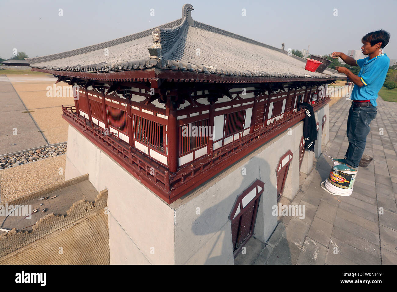 Un lavoratore cinese riparazioni parte di una replica in miniatura della Dinastia Tang Daming Palace costruito sul suo sito originale come abitazione e i grattacieli che circondano il patrimonio nazionale sito in Xi'an, la capitale della Cina in provincia di Shaanxi, il 25 settembre 2016. Come la Cina si precipita verso la modernizzazione, affronta le stesse questioni come i paesi sviluppati hanno dovuto affrontare - che cosa conservare e cosa di demolire in nome dei posteri e del progresso. Foto di Stefano rasoio/UPI Foto Stock