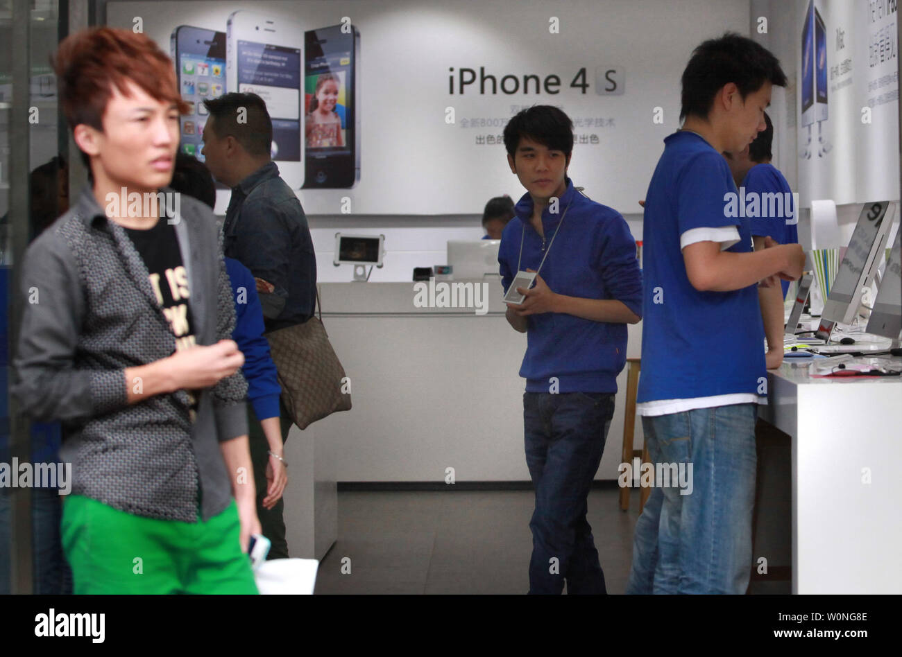 I dipendenti cinesi vestito come ufficiale lo staff di Apple in un negozio di computer stessa reclamizza come un dipendente Apple Store aiutano i clienti a fare acquisti per i prodotti Apple in Kunming, la capitale della provincia dello Yunnan, il 21 settembre 2012. Kunming ha avuto diversi 'Apple' memorizza di cessare e desistere fare per flagrante copyright e marchio di infrazioni. UPI/Stephen rasoio Foto Stock