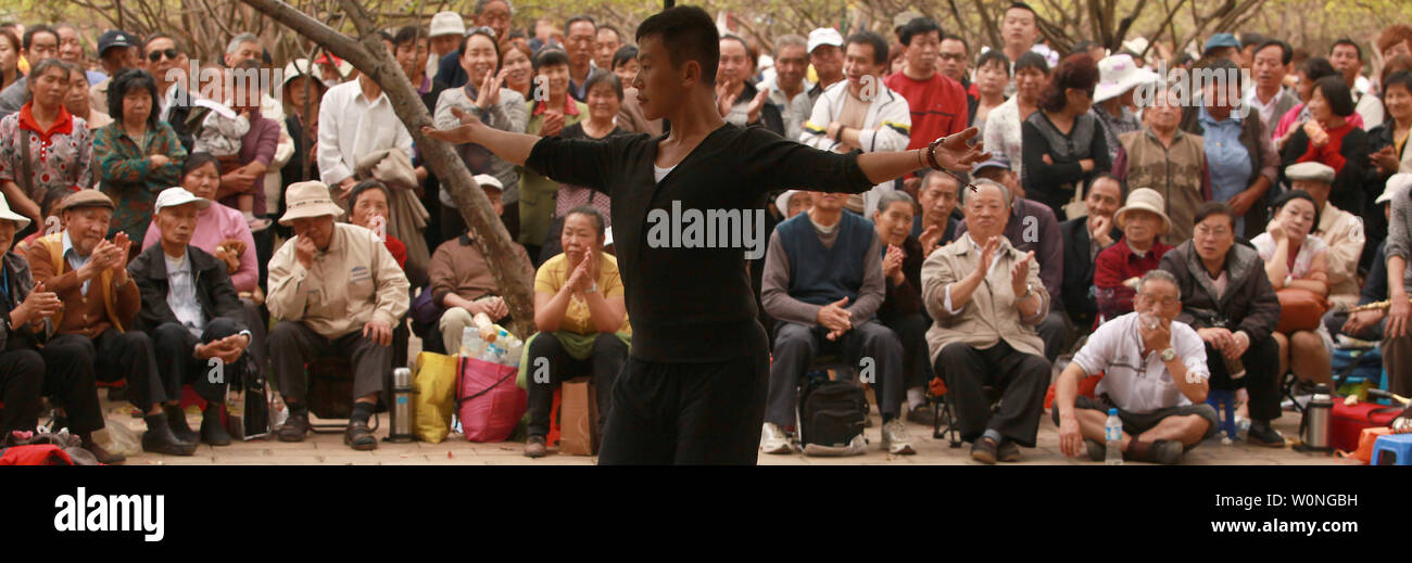 Una grande folla orologi uomo eseguire una interpretazione moderna di un famoso comunista canzone patriottica in un parco in Kunming, la capitale della Cina meridionale della provincia dello Yunnan, il 22 settembre 2012. Parchi hanno sempre giocato un ruolo importante del paese è il passato comunista, ancor di più oggi, mantenendo vecchie canzoni patriottiche e danze vivo. UPI/Stephen rasoio Foto Stock