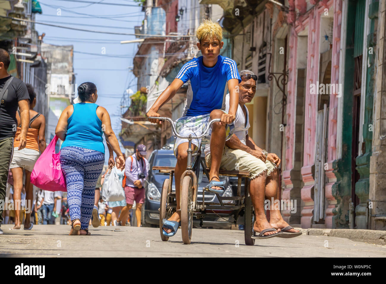 L'Avana, Cuba - 16 Maggio 2019: il popolo cubano in sella ad una bicicletta in strada di l'Avana Vecchia Città durante un vivace e luminosa giornata di sole. Foto Stock